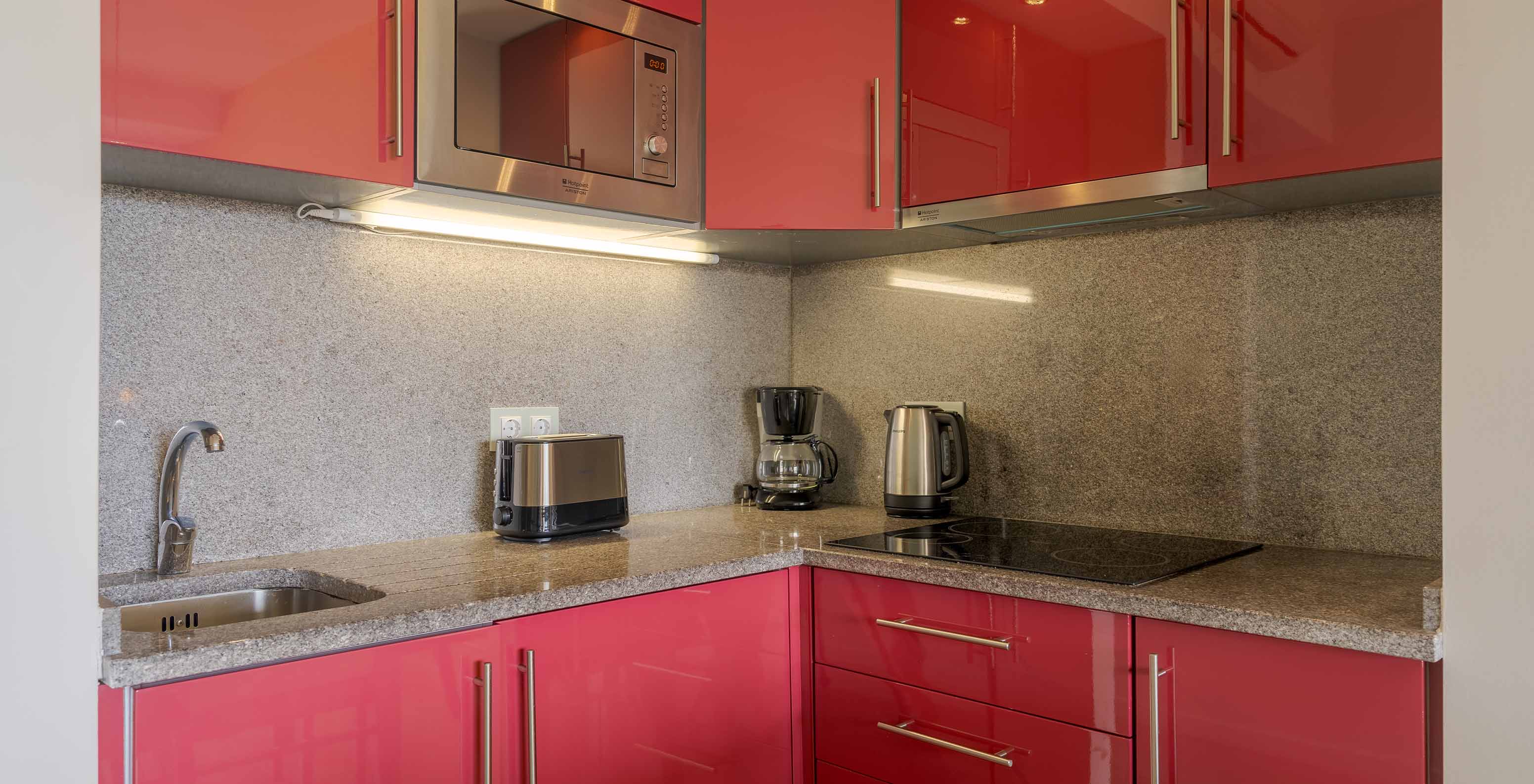 De Suite T2 Duplex met uitzicht op de zee van Pestana Alvor Praia heeft keuken met fornuis, magnetron, waterkoker en toaster