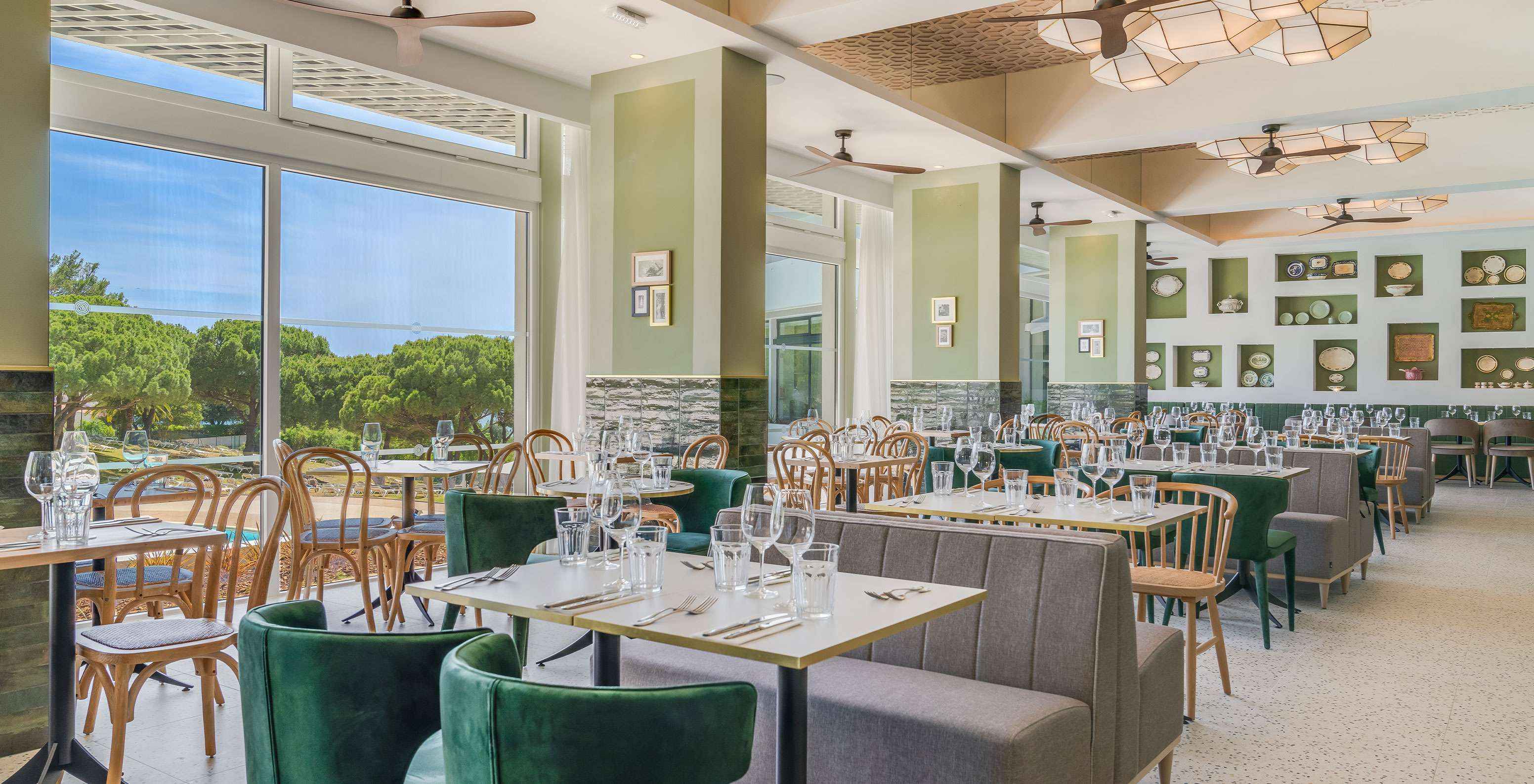 Het restaurant Luigi, van het all-inclusive hotel in de Algarve, heeft tafels met banken en comfortabele stoelen