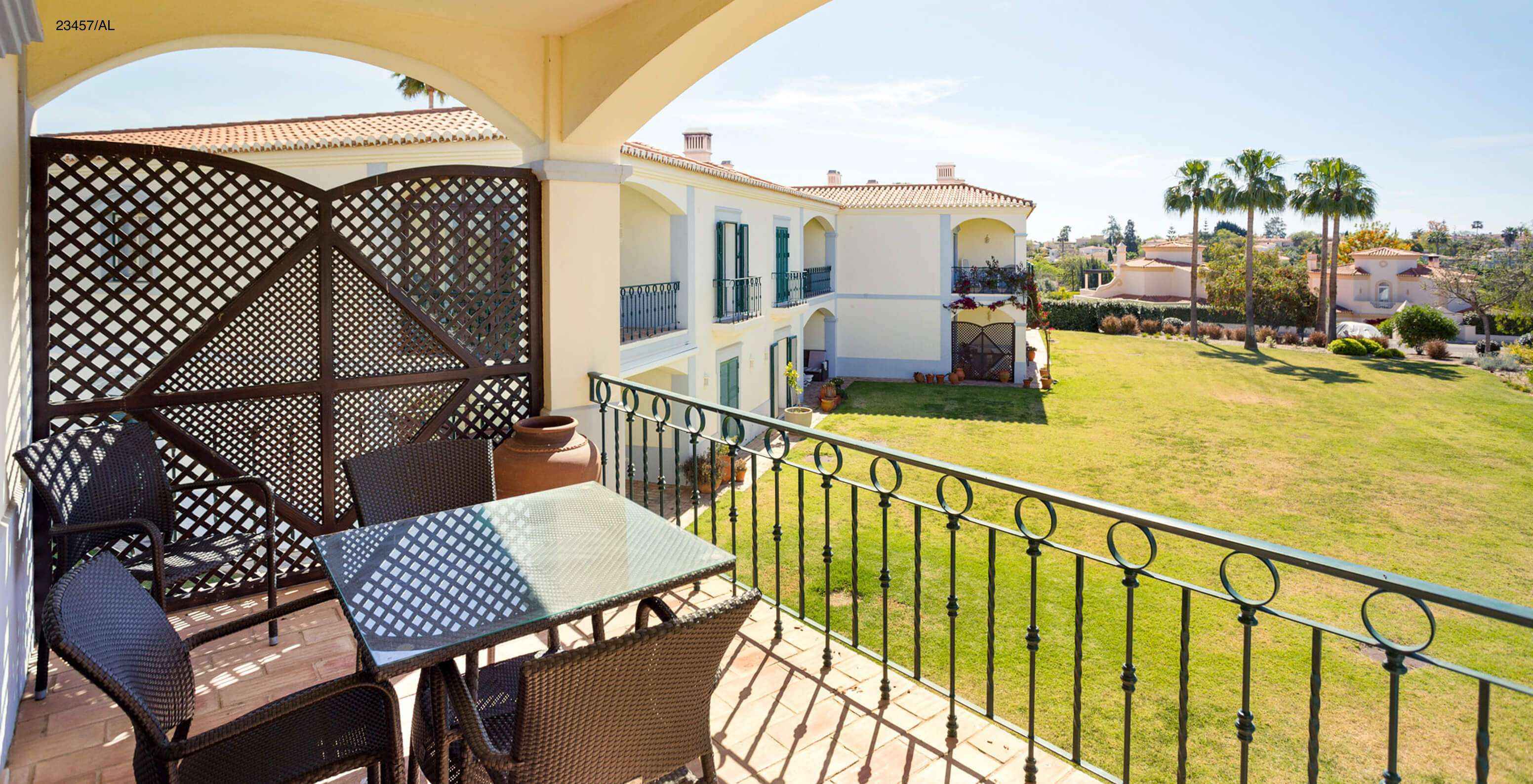 Het appartement Pestana Carvoeiro Golf T3 Standard heeft een balkon met een tafel, stoelen en uitzicht op de tuin