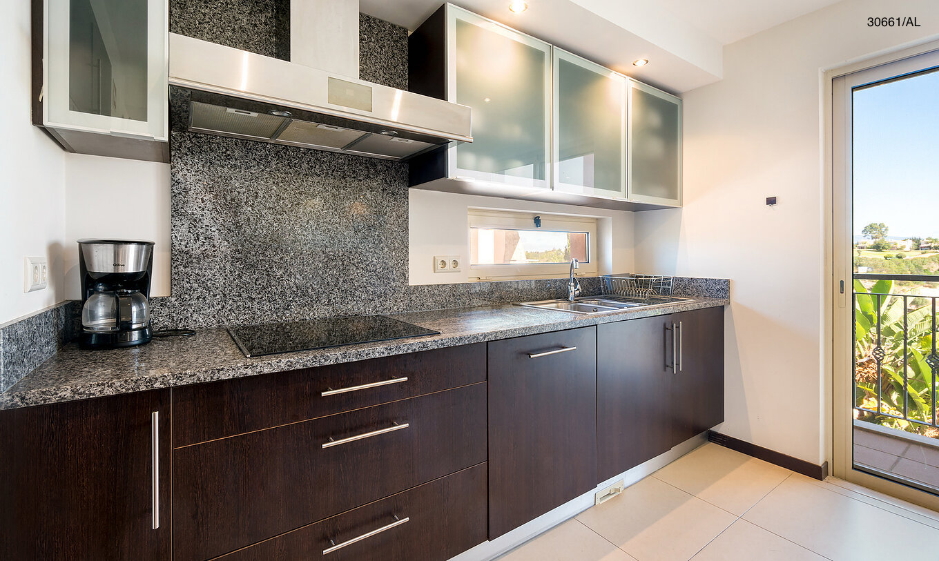 Het appartement Pestana Carvoeiro Golf T1 Superior heeft een keuken met houten kasten en een granieten werkblad