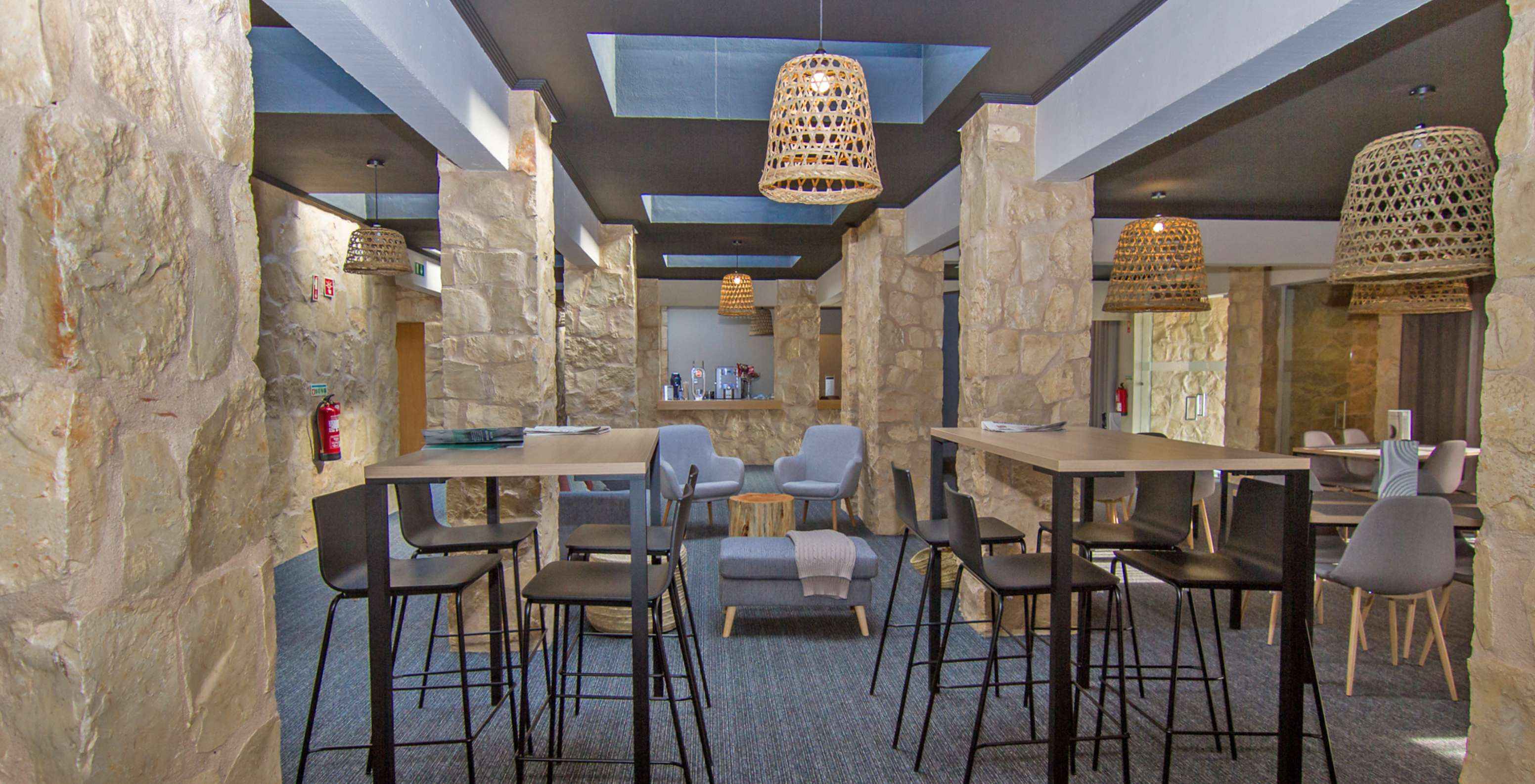 Restaurant van hotel met zwembad, gelegen op een golfbaan, met twee hoge tafels en tafels met comfortabele stoelen