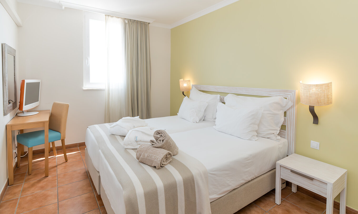 De Suite Zeezicht van Pestana Viking heeft een kamer met twee bedden, nachtkastje en bureau met stoel