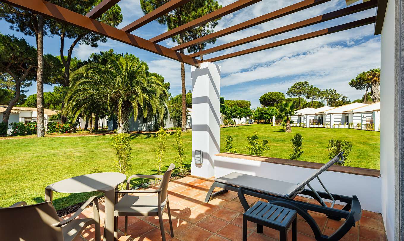 De Superior Garden View bij Pestana Vila Sol - Vilamoura heeft balkon met ligstoel, tafel en uitzicht op de tuin
