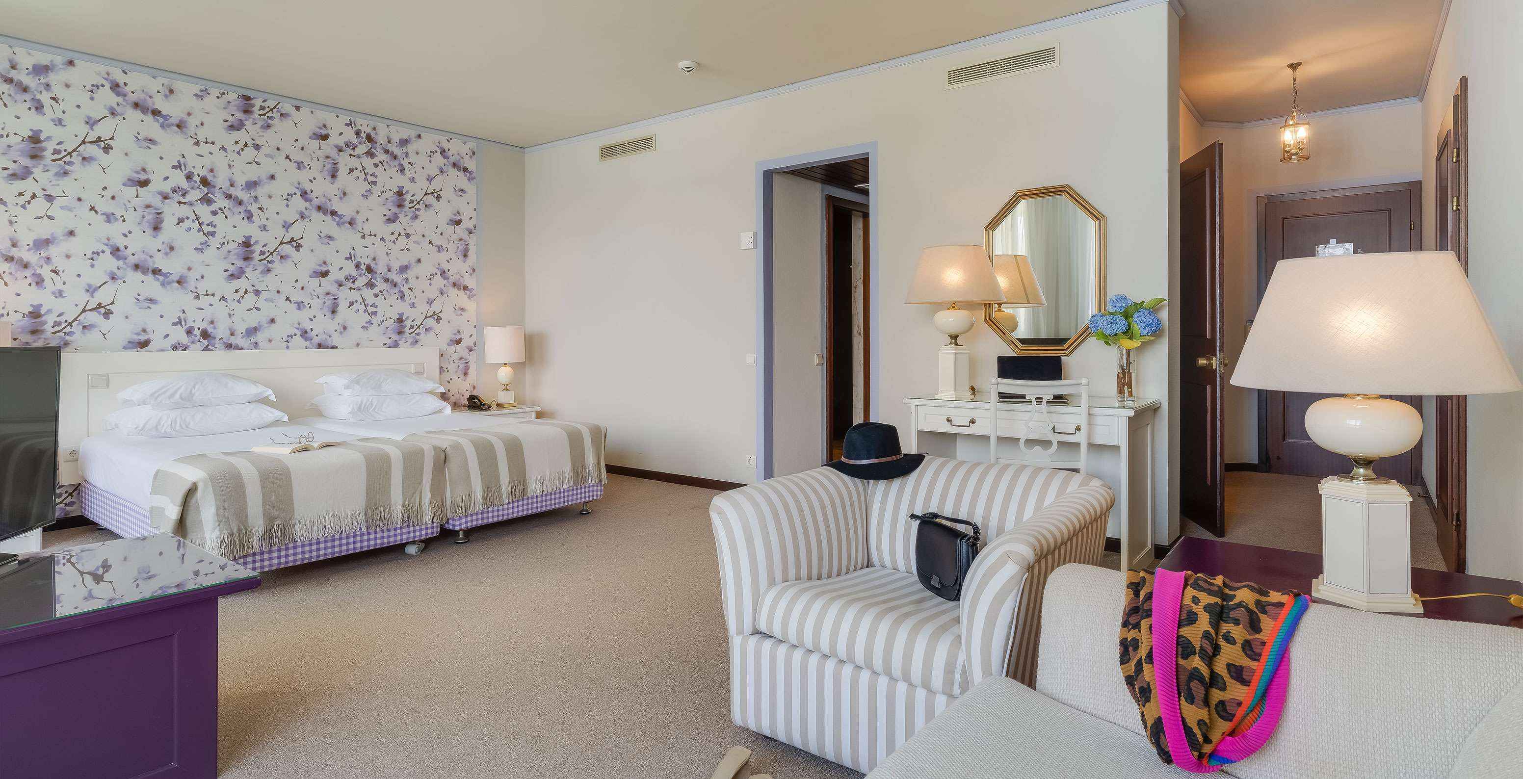 In Junior Suite Zeezicht van Pestana Bahia Praia staan de bedden naast het balkon met uitzicht op tuinen en zee