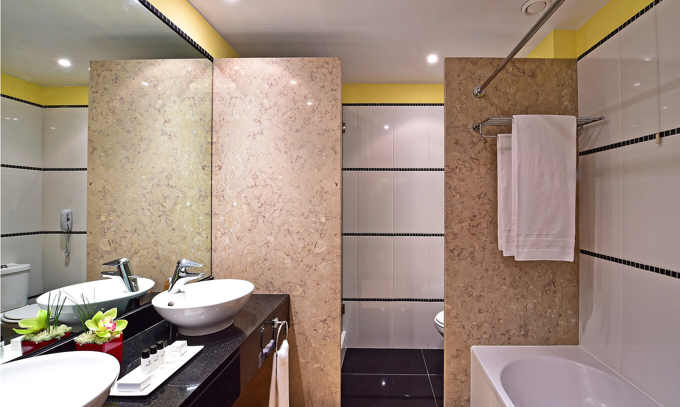 De Junior Suite van Pestana Sintra Golf heeft een badkamer met twee wastafels met spiegel, voorzieningen en een bad