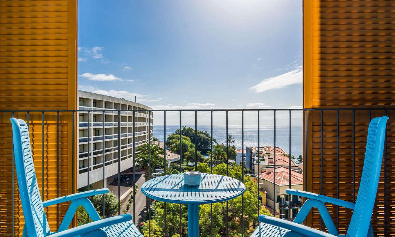 Het Deluxe Studio van Pestana Casino Studios heeft een balkon met uitzicht op de stad en een tafel met blauwe stoelen