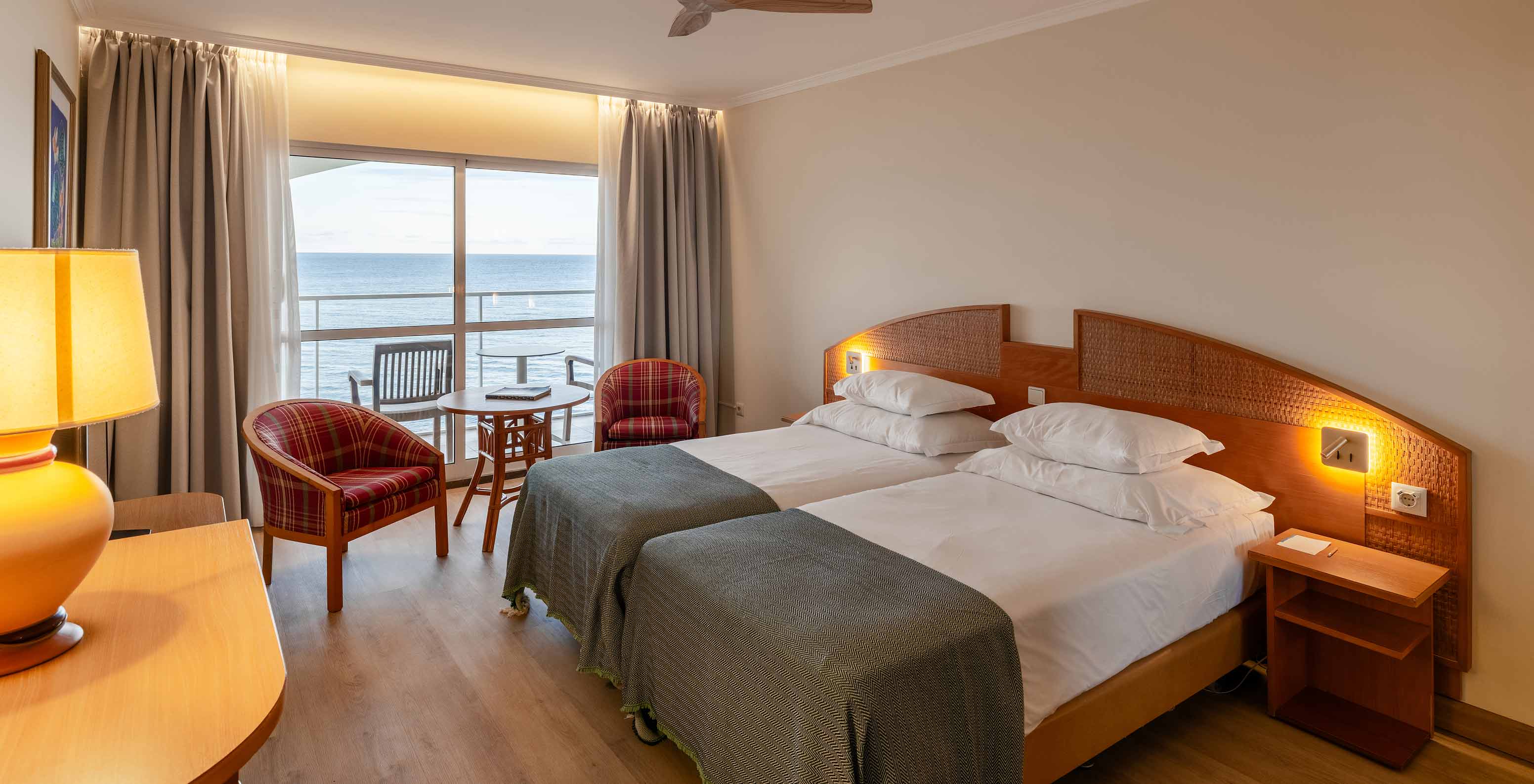De Superior Sea View van het Pestana Ocean Bay All Inclusive heeft een tweepersoonsbed met een groene sprei en een balkon