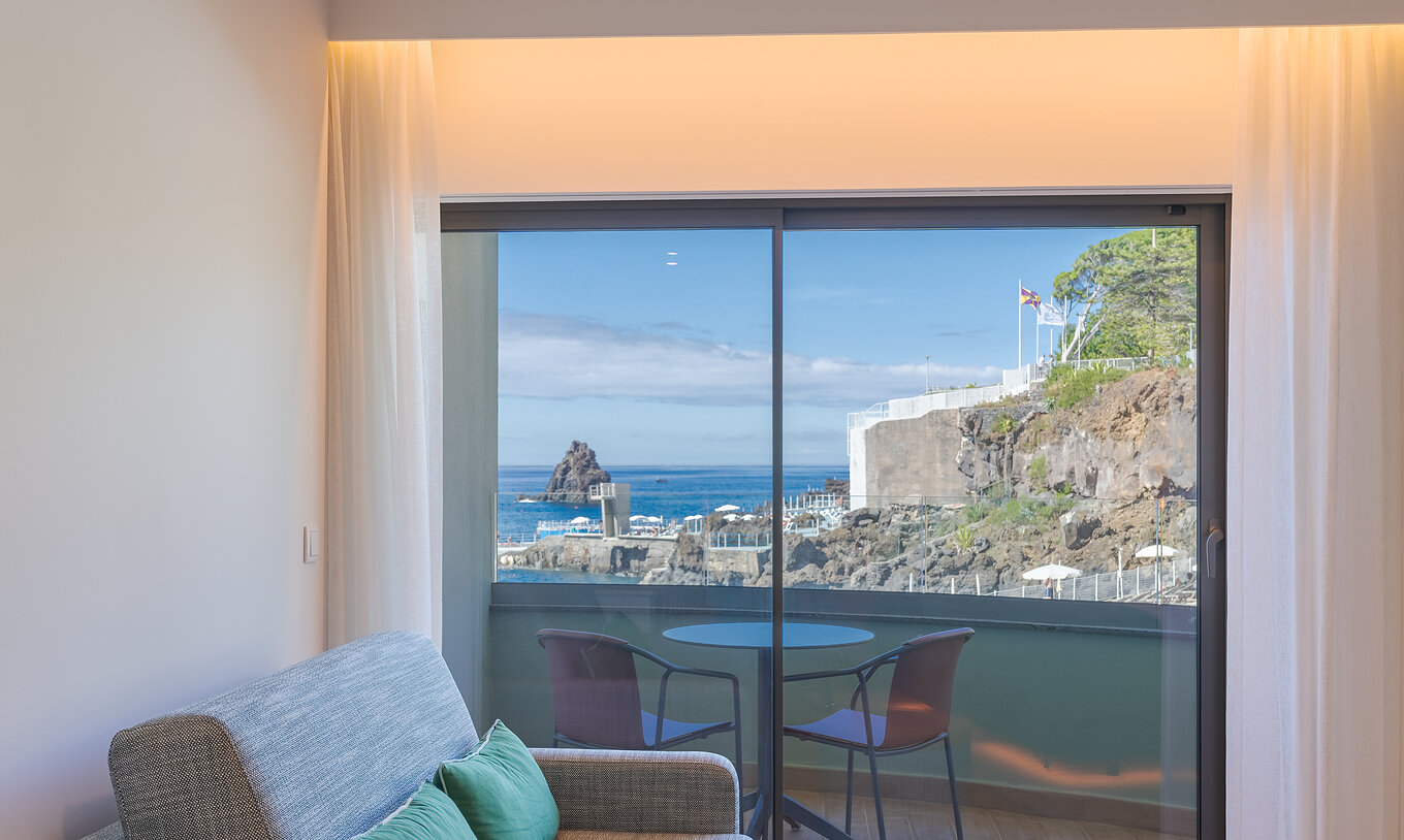 De Classic Sea View Side kamer van Pestana Vila Lido Madeira heeft een bank naast het balkon met zijdelings zeezicht
