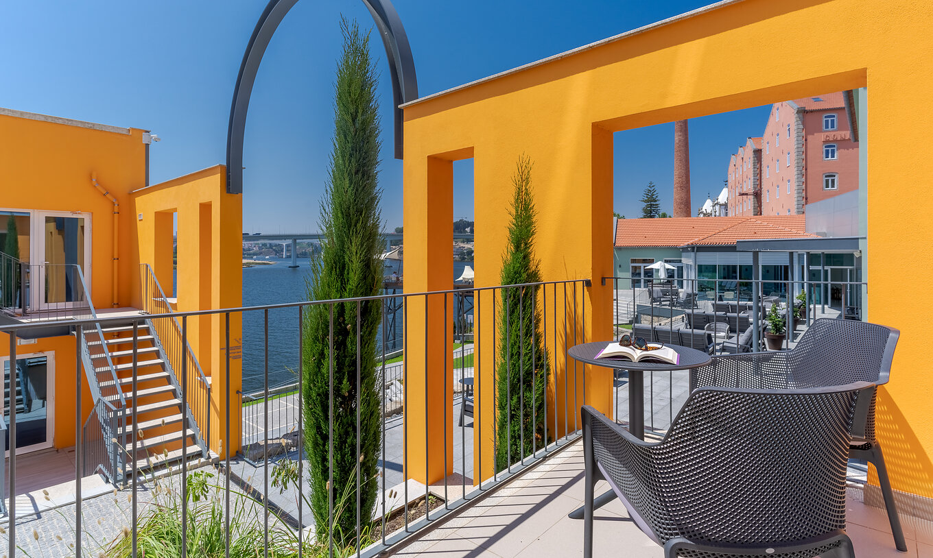 De River View kamer van Pestana Douro Riverside heeft een balkon met tafel en stoelen, en uitzicht op de Douro