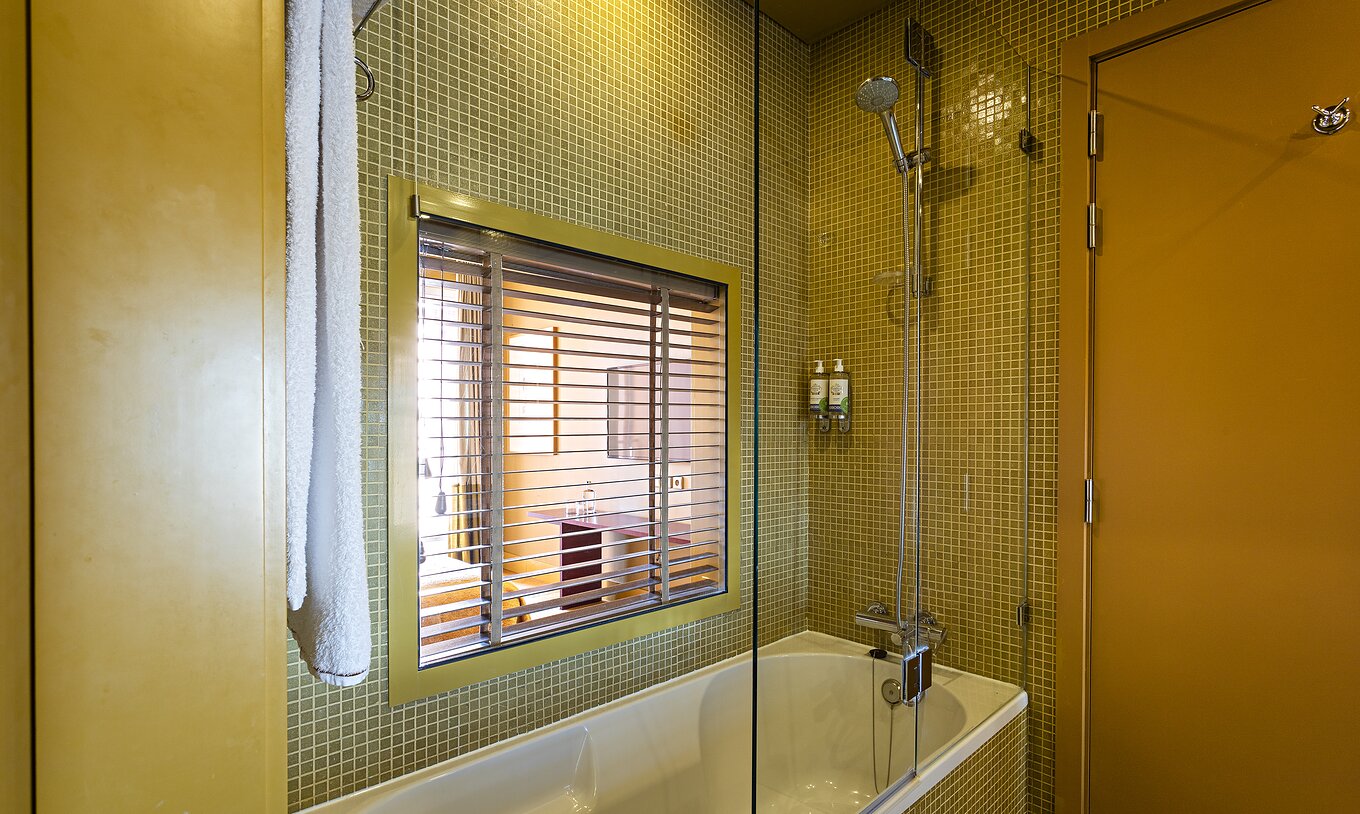 De Suite Balcony heeft een badkamer met bad en raam naar de slaapkamer