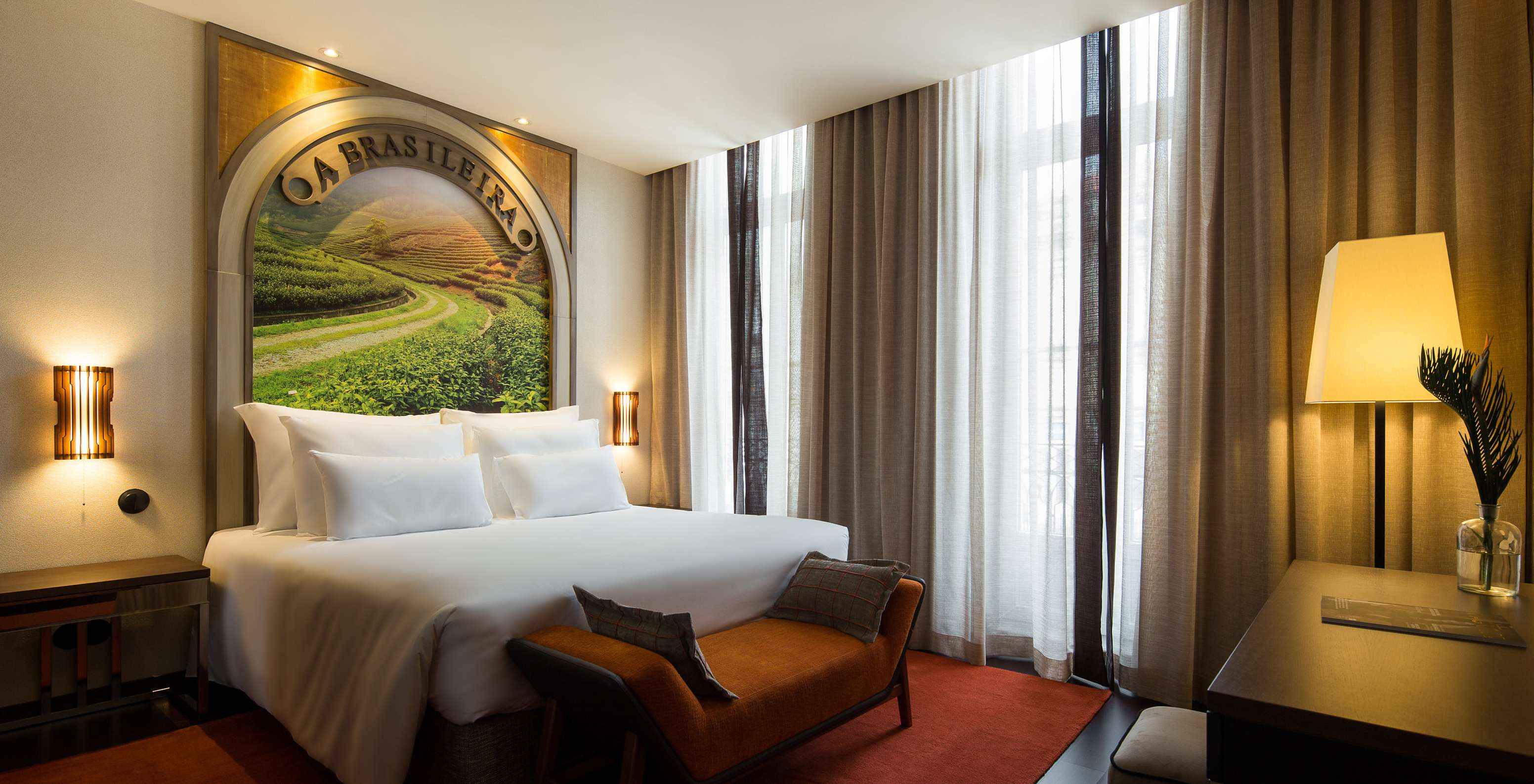 De Deluxe Superior van Pestana Porto - A Brasileira heeft een bed met een thema muurschildering op het hoofdeind en een bank