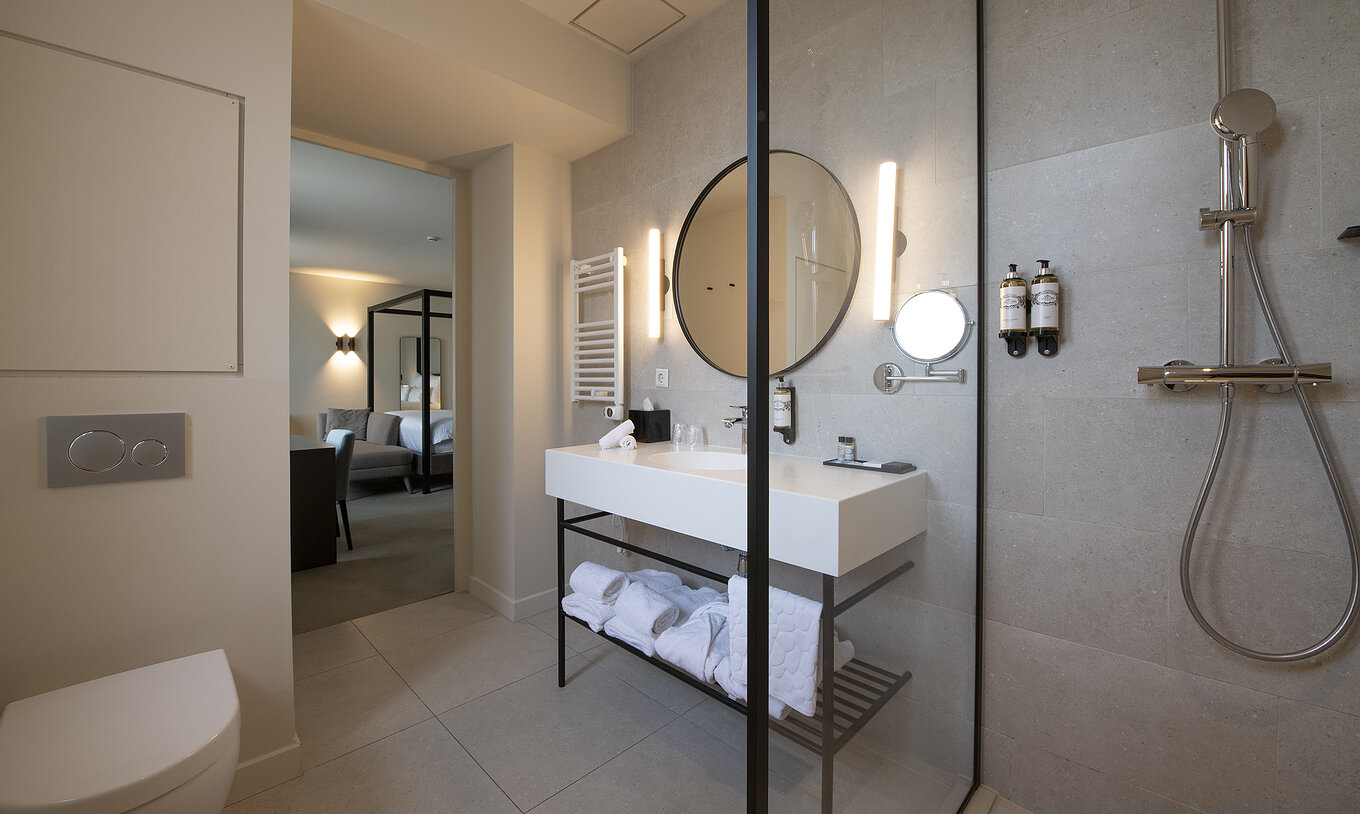 De Premium Deluxe kamer van Pestana Amsterdam Riverside heeft een badkamer met spiegel, wastafel, handdoeken en douche