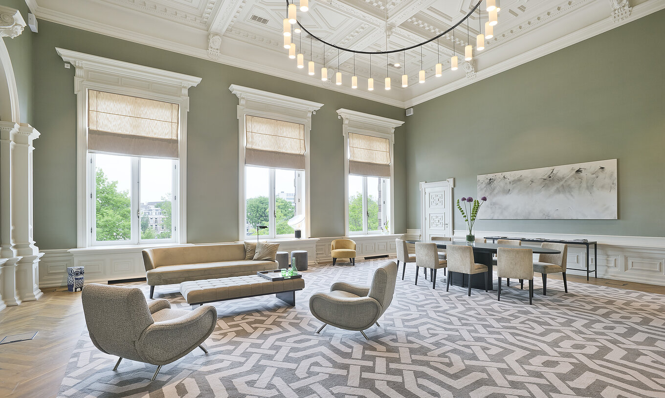 Presidencial Master Suite - River View van Pestana Amsterdam Riverside heeft woonkamer met bank en stoelen en tafel