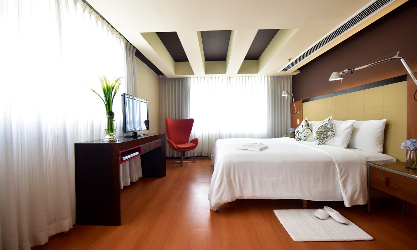 De Suite Presidencial van Pestana Caracas heeft een tweepersoonsbed, twee nachtkastjes en een televisie voor het bed