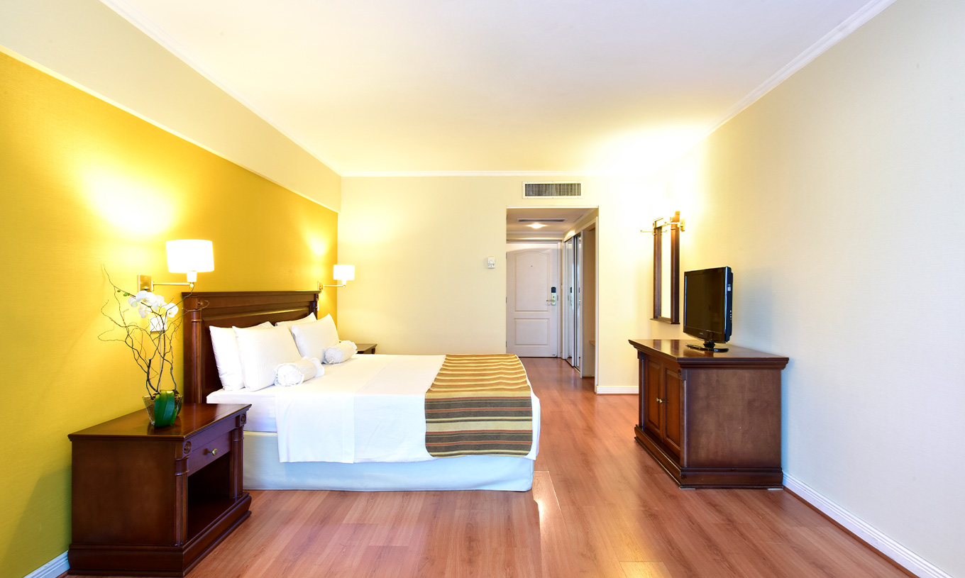 O quarto Queen Superior do Pestana Buenos Aires conta uma cama de casal, televisão, espelho e mesa de cabeçeira com candeeiro