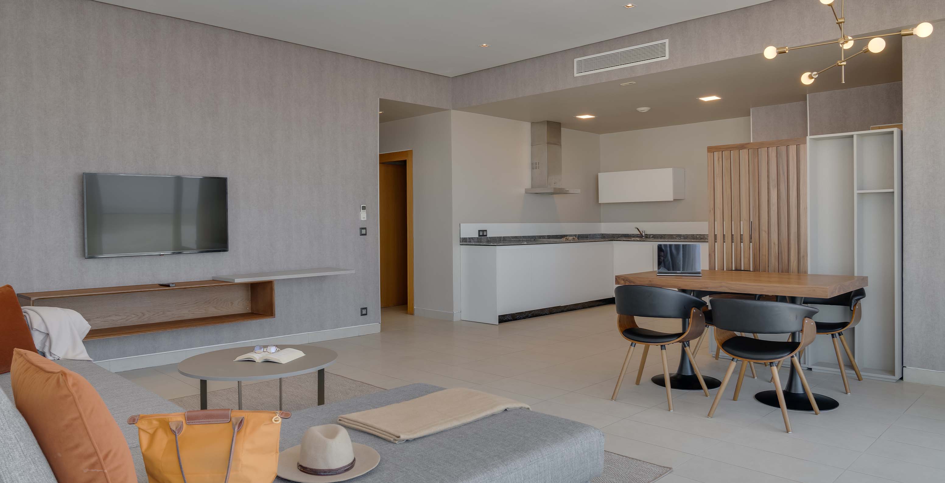 A Suite Familiar Corniche do Pestana Casablanca tem uma sala espaçosa com sofá, tv, mesa de refeição e kitchenette