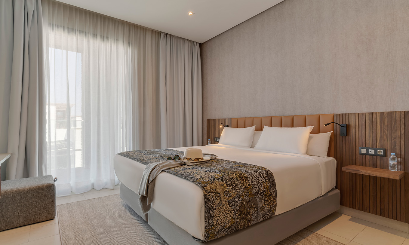 A Suite Familiar Corniche do Pestana Casablanca tem um quarto com uma cama de casal com uma decoração moderna