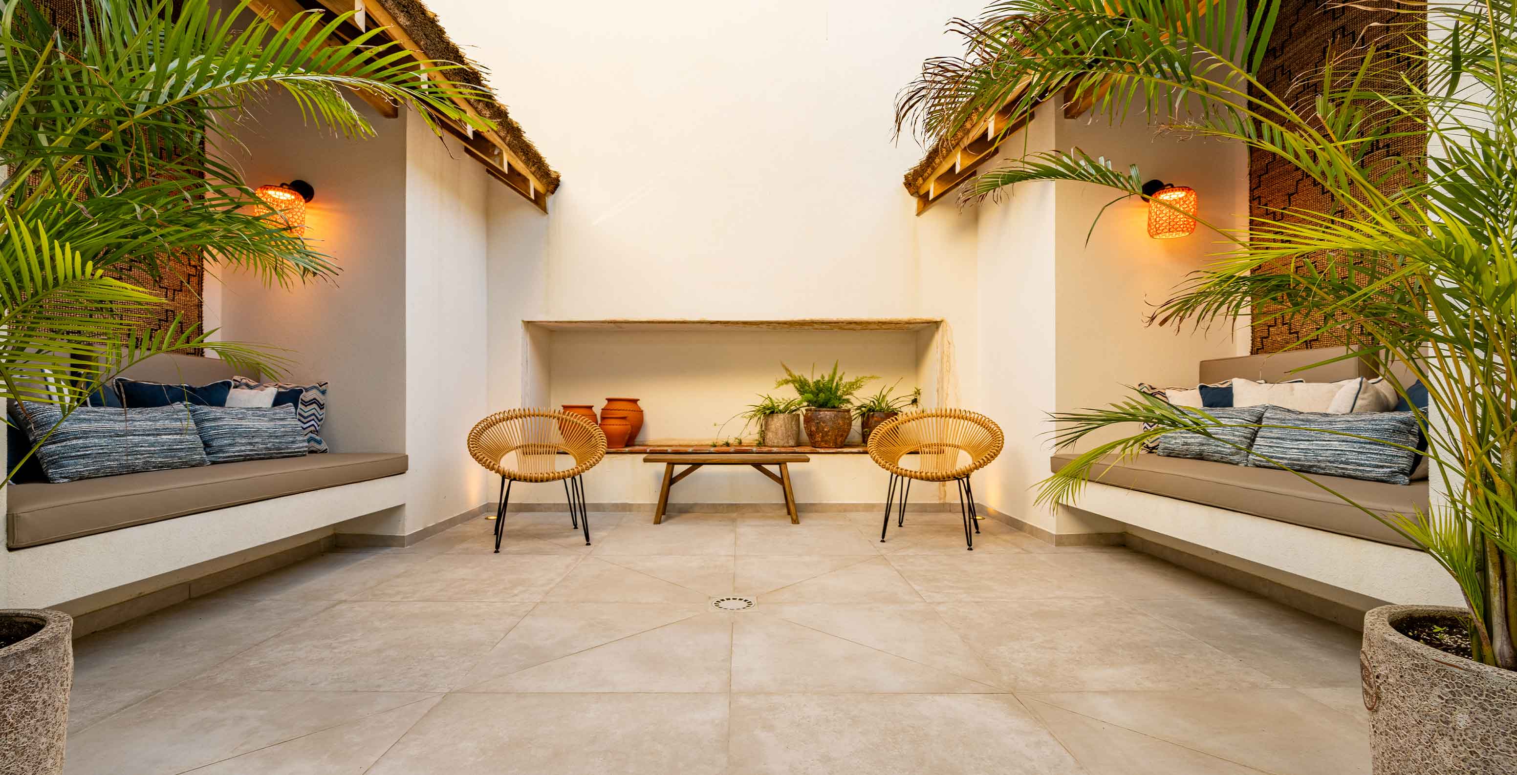 Área de estar ao ar livre com bancos, cadeiras e vegetação, no Pestana Comporta Village Residences