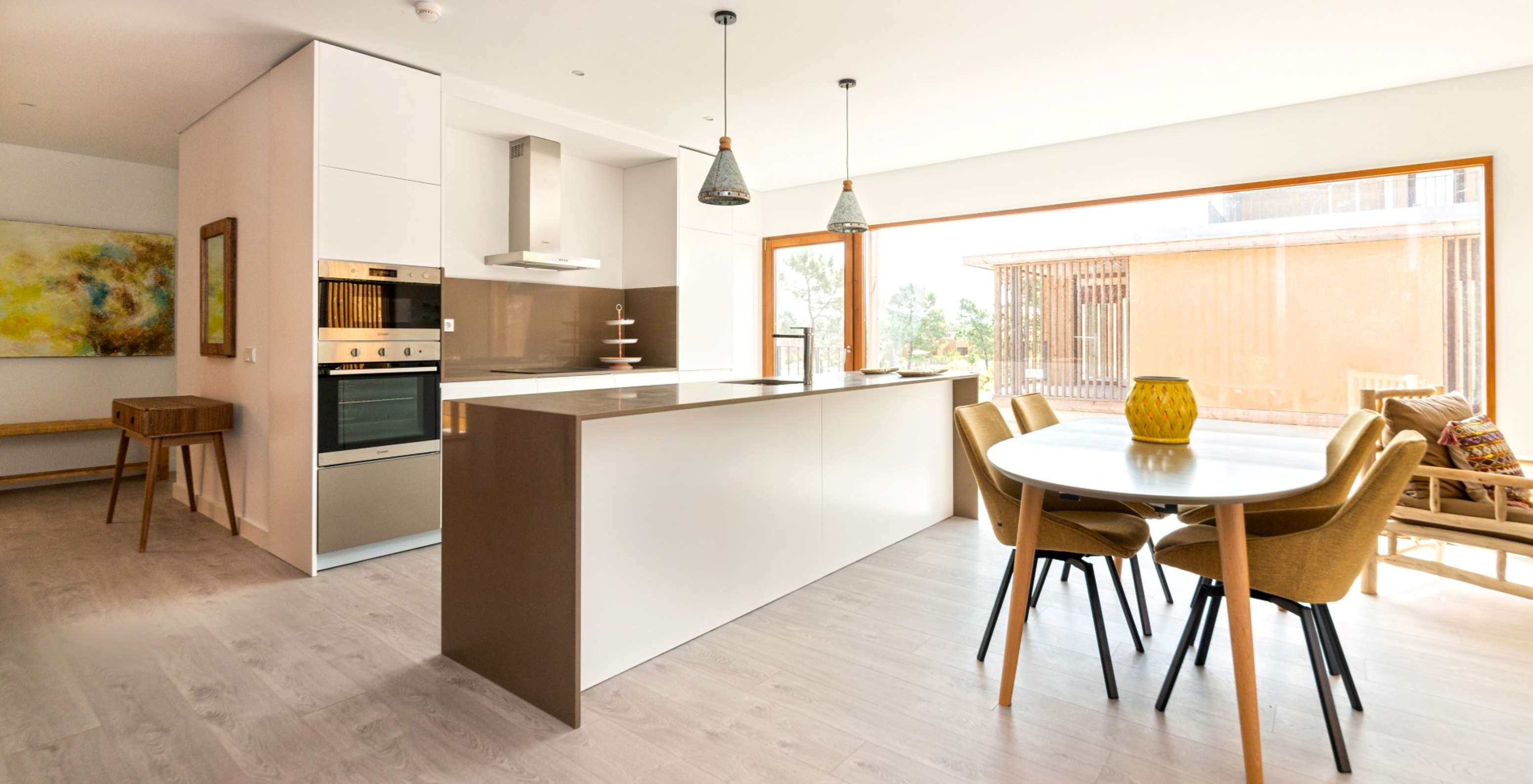 O Apartamento Eco Village 1º Andar Vistas do Pestana Tróia Eco Resort tem uma cozinha com bancada e uma mesa com cadeiras