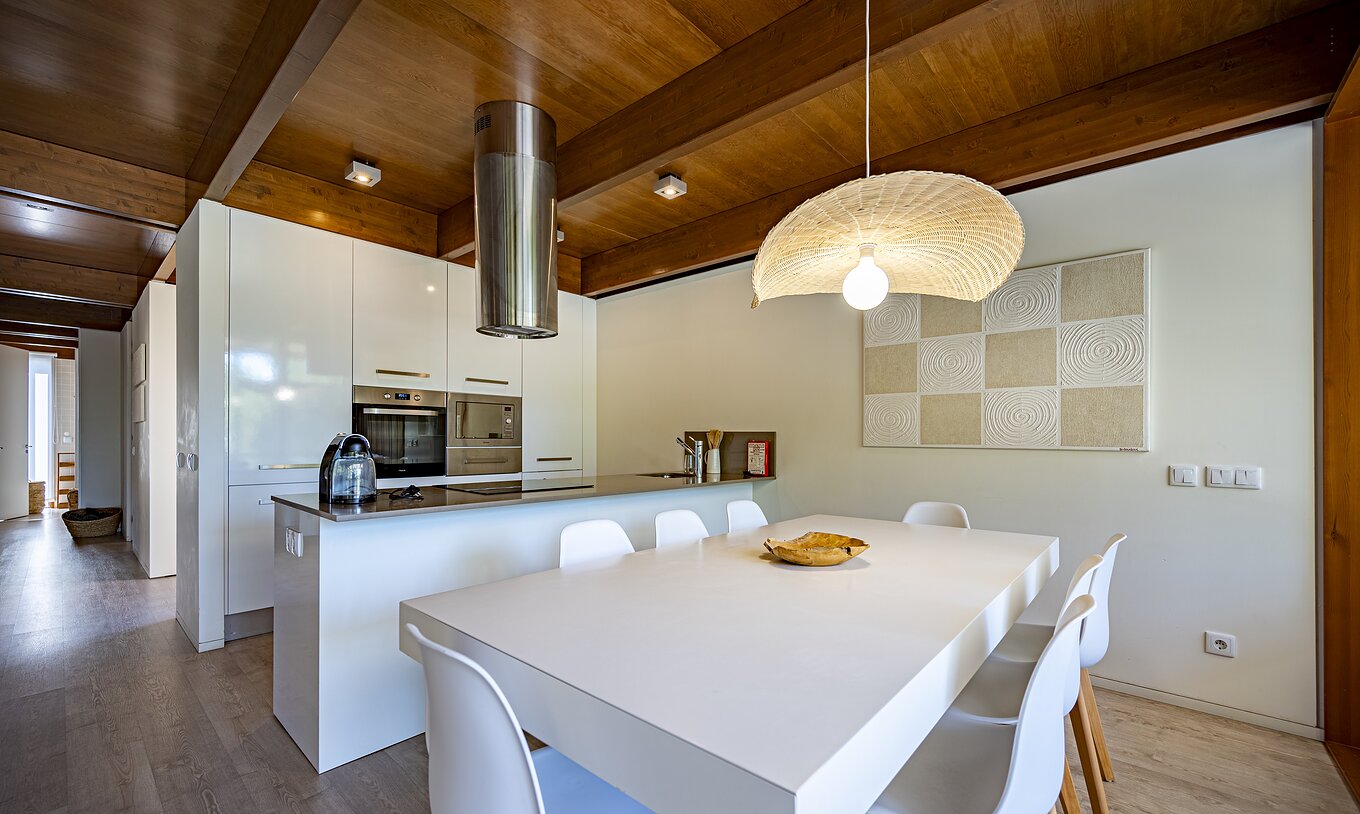 A Tree Villa com Piscina Privada do Pestana Tróia Eco Resort tem uma cozinha equipada e uma mesa e cadeiras ao lado