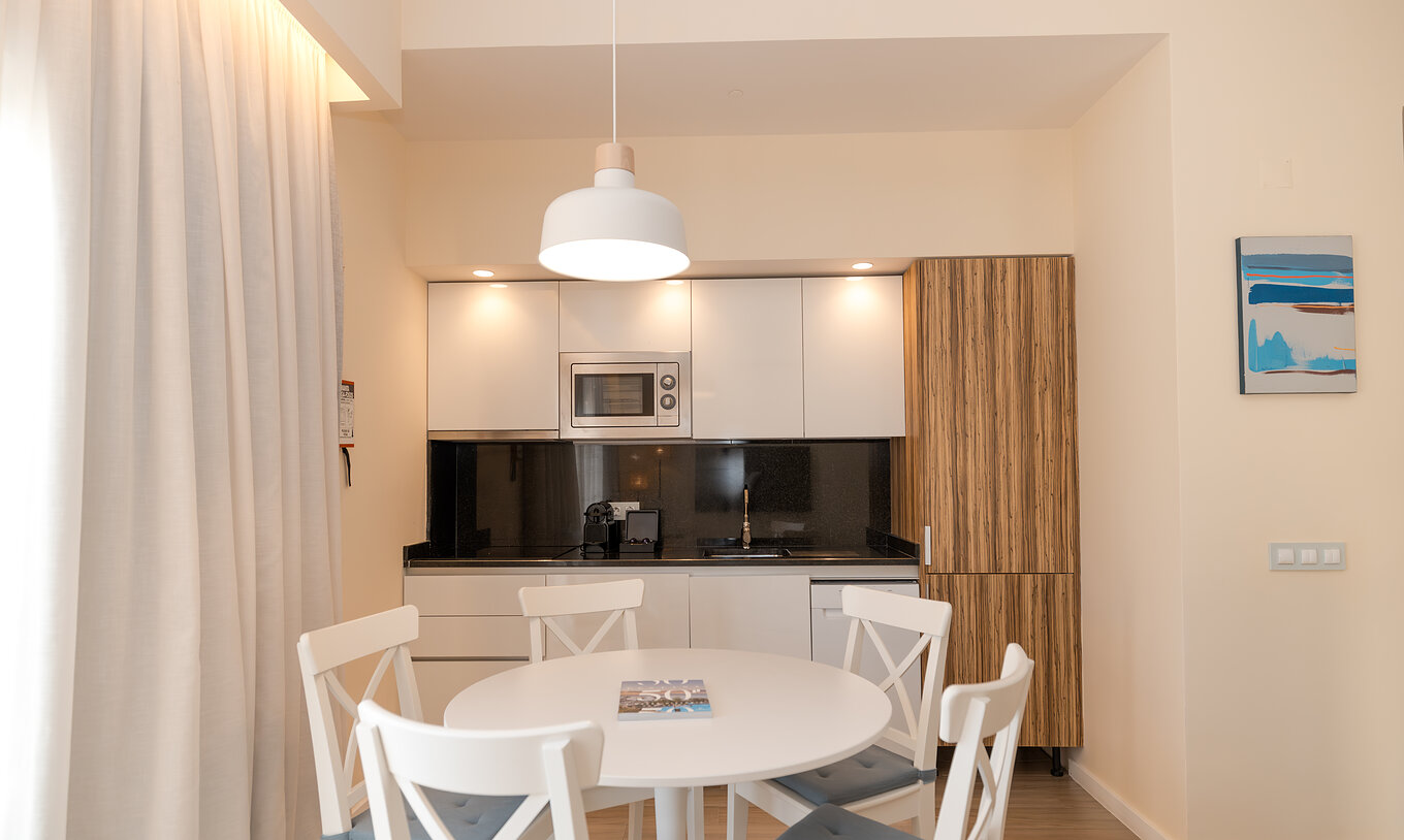 A Villa 2 Quartos Superior Vista Jardim do Pestana Alvor Beach Villas tem uma mesa para refeições e uma cozinha equipada