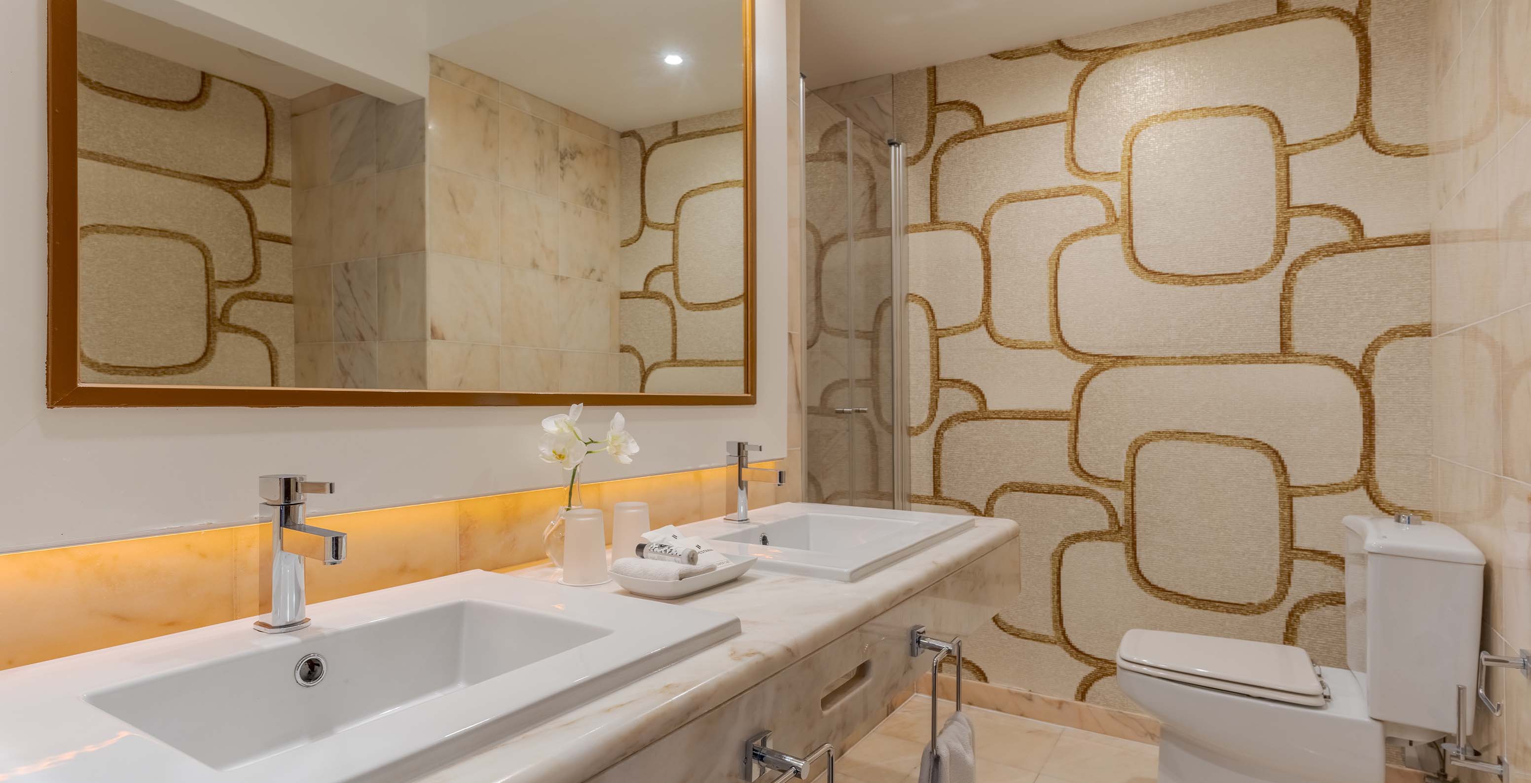 O Deluxe Vista Mar do Pestana Alvor Praia tem casa de banho em mármore com dois lavatórios, espelho grande e sanita