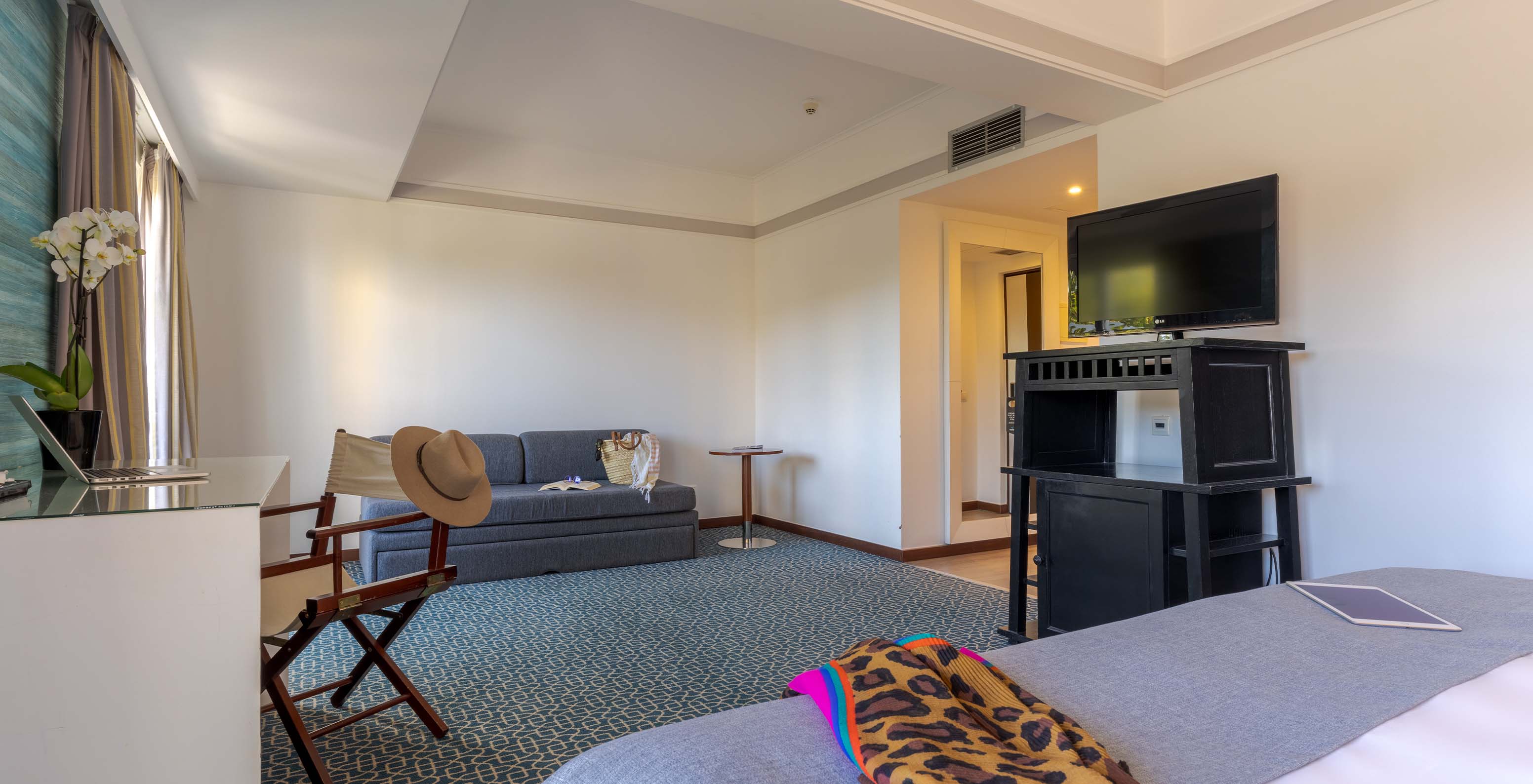 O Superior do Pestana Alvor Praia tem uma cama de casal, um móvel preto com a televisão, um sofá-cama e uma secretária