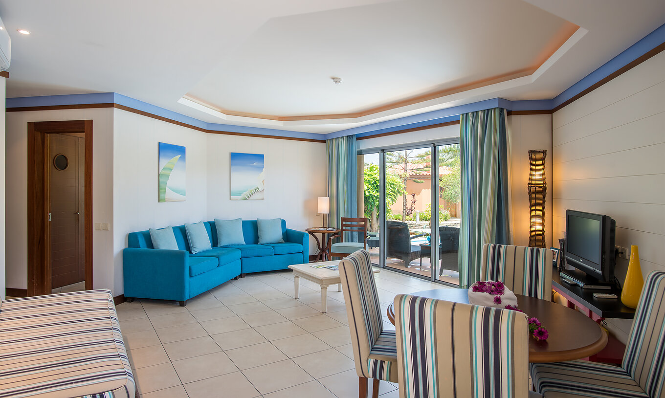 A Pool Villa do Pestana Porto Santo All Inclusive tem uma sala com janela, mesa e cadeiras, sofá e uma televisão