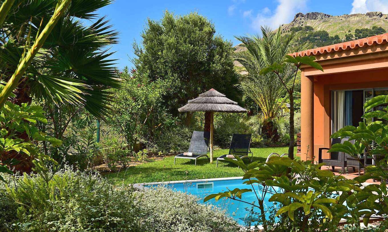 A Pool Villa do Pestana Porto Santo All Inclusive tem uma piscina privada, espreguiçadeiras e um chapéu de palha