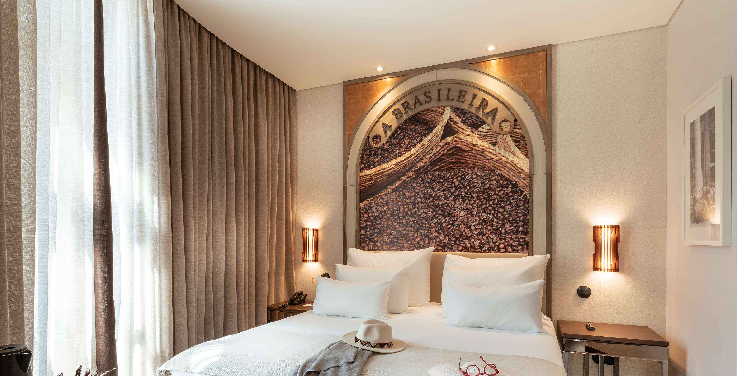 O Deluxe do Pestana Porto - A Brasileira tem uma cama de casal com um mural temático na cabeceira da cama