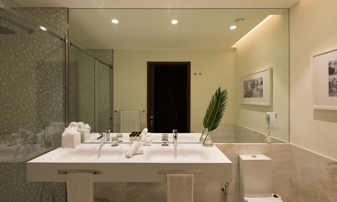 O Deluxe Executive do Pestana Porto - A Brasileira tem uma casa de banho com dois lavatórios e uma sanita com chuveiro