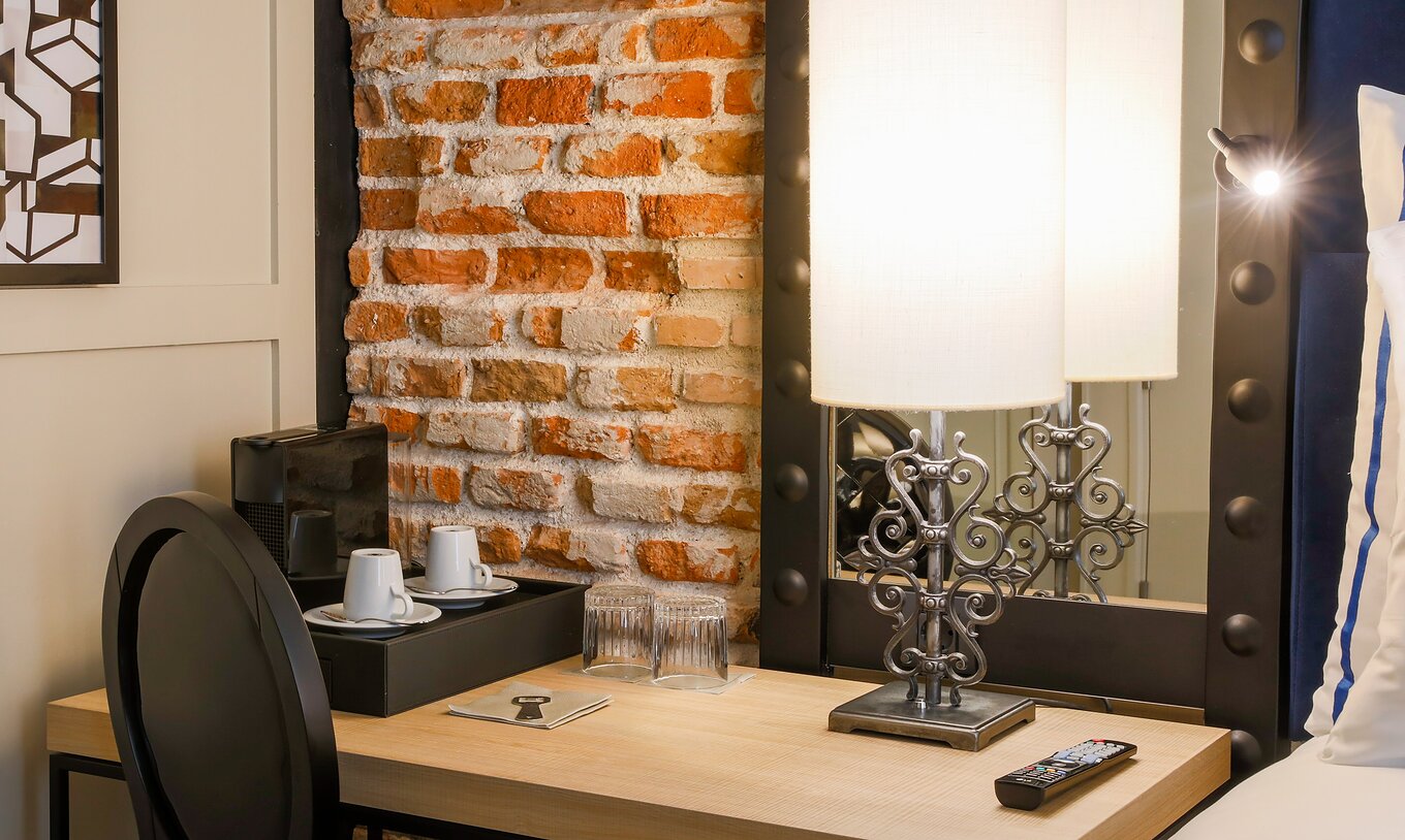 O Superior do Pestana Plaza Mayor Madrid tem uma secretária, uma cadeira, um espelho e uma máquina de café nespresso