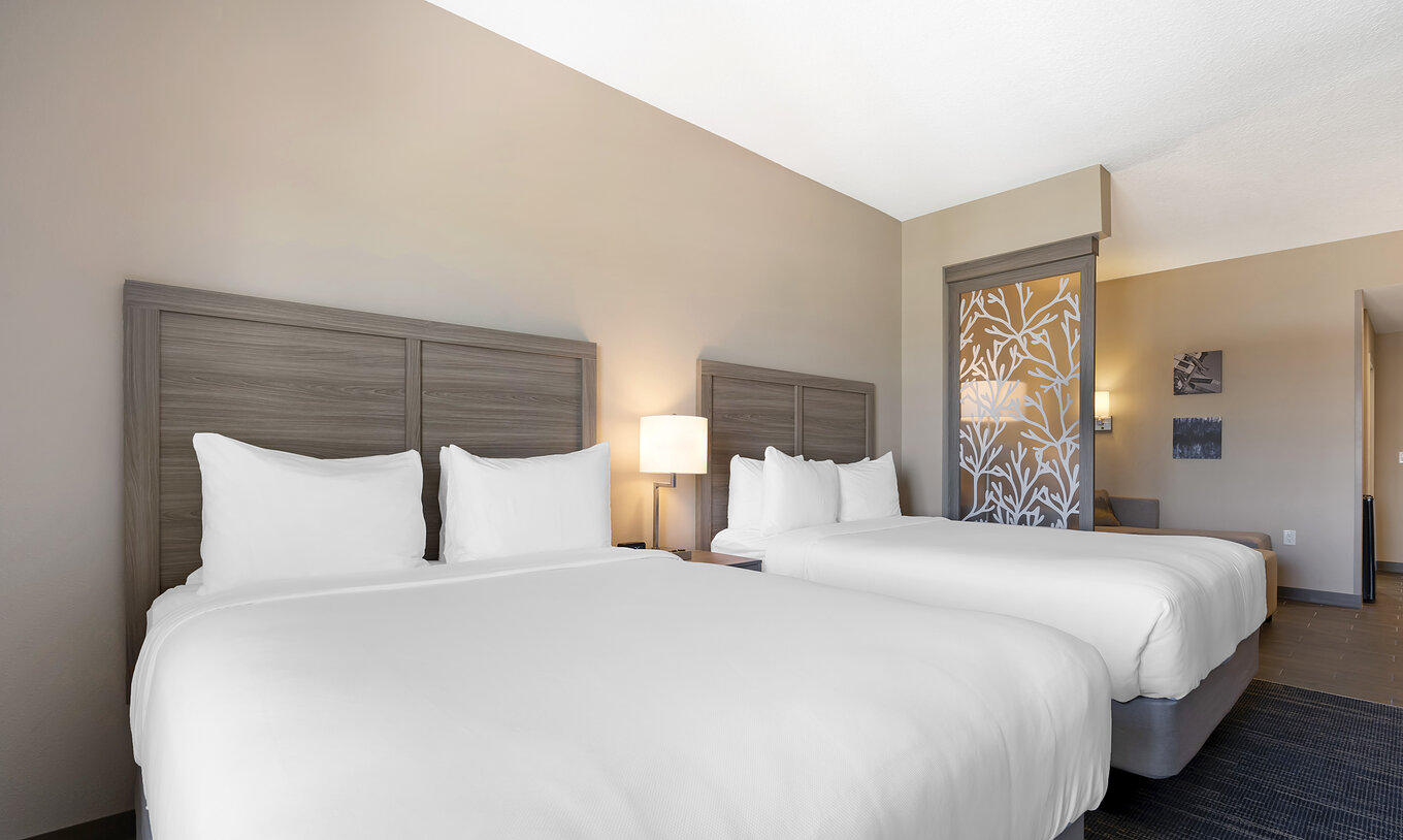 A Suite Dupla Queen ADA do Pestana Orlando Suites Lake Buena Vista tem duas camas de casal e mesa de cabeceira com candeeiro