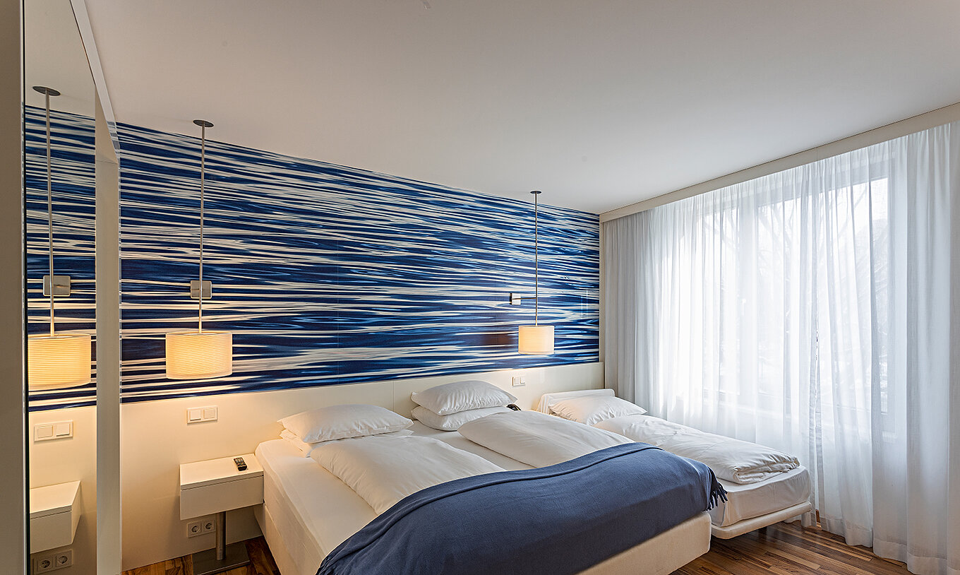 O Family Deluxe do Pestana Berlin Tiergarten tem uma cama de casal ou duas individuais e um papel de parede em tons de azul