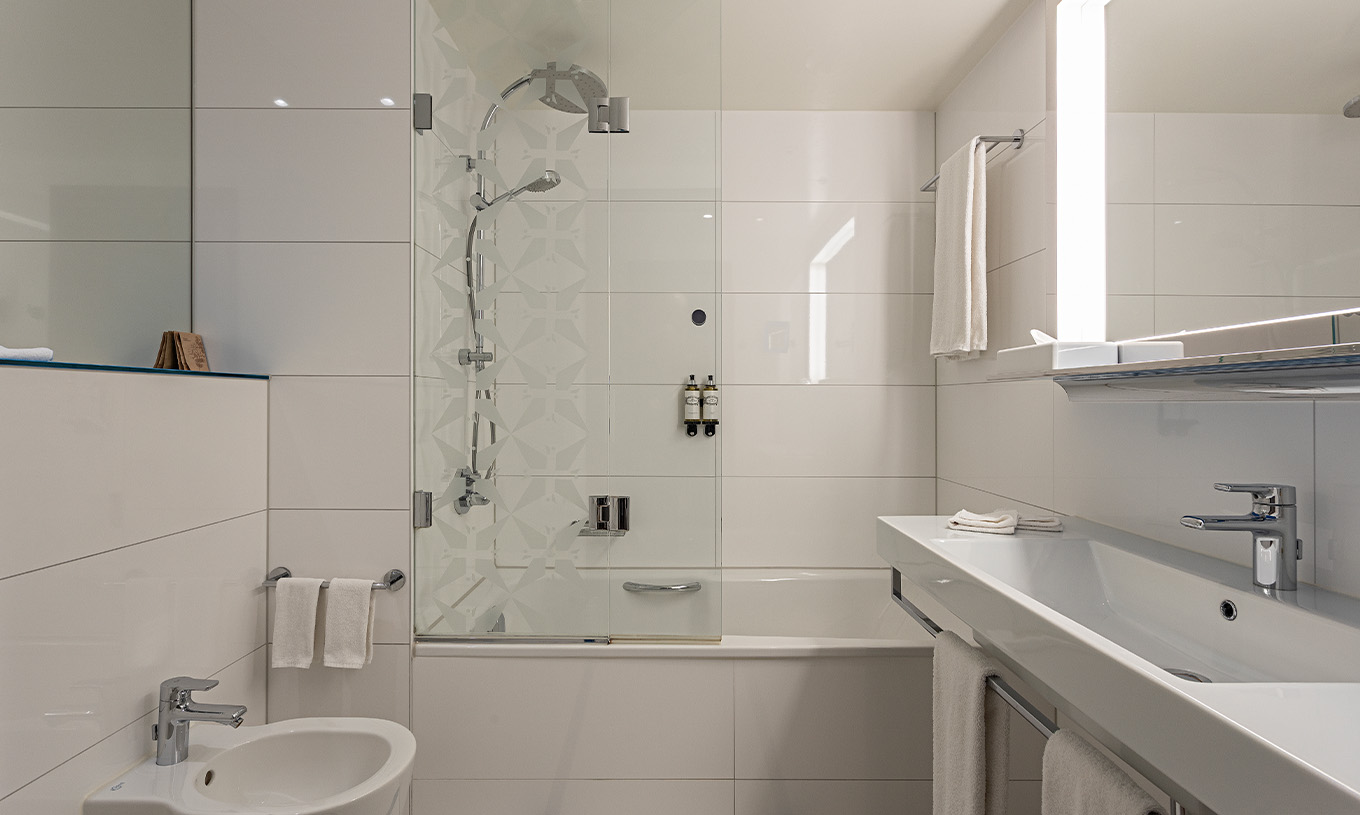 O quarto Grand Deluxe do Pestana Berlin Tiergarten conta com casa de banho com banheira e chuveiro, e um lavatório