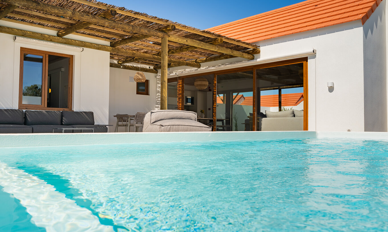 A Premium Green Villa do Pestana Comporta Village Residences tem uma piscina exterior, uma zona com sofás e uma mesa 