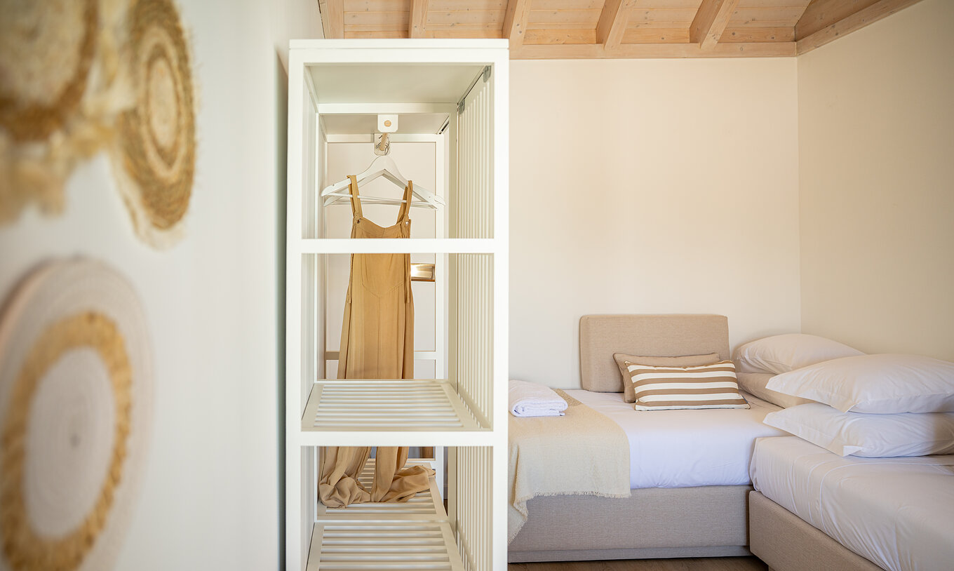 A Standard Villa do Pestana Comporta Village Residences tem um closet com um roupeiro branco e decoração de palha