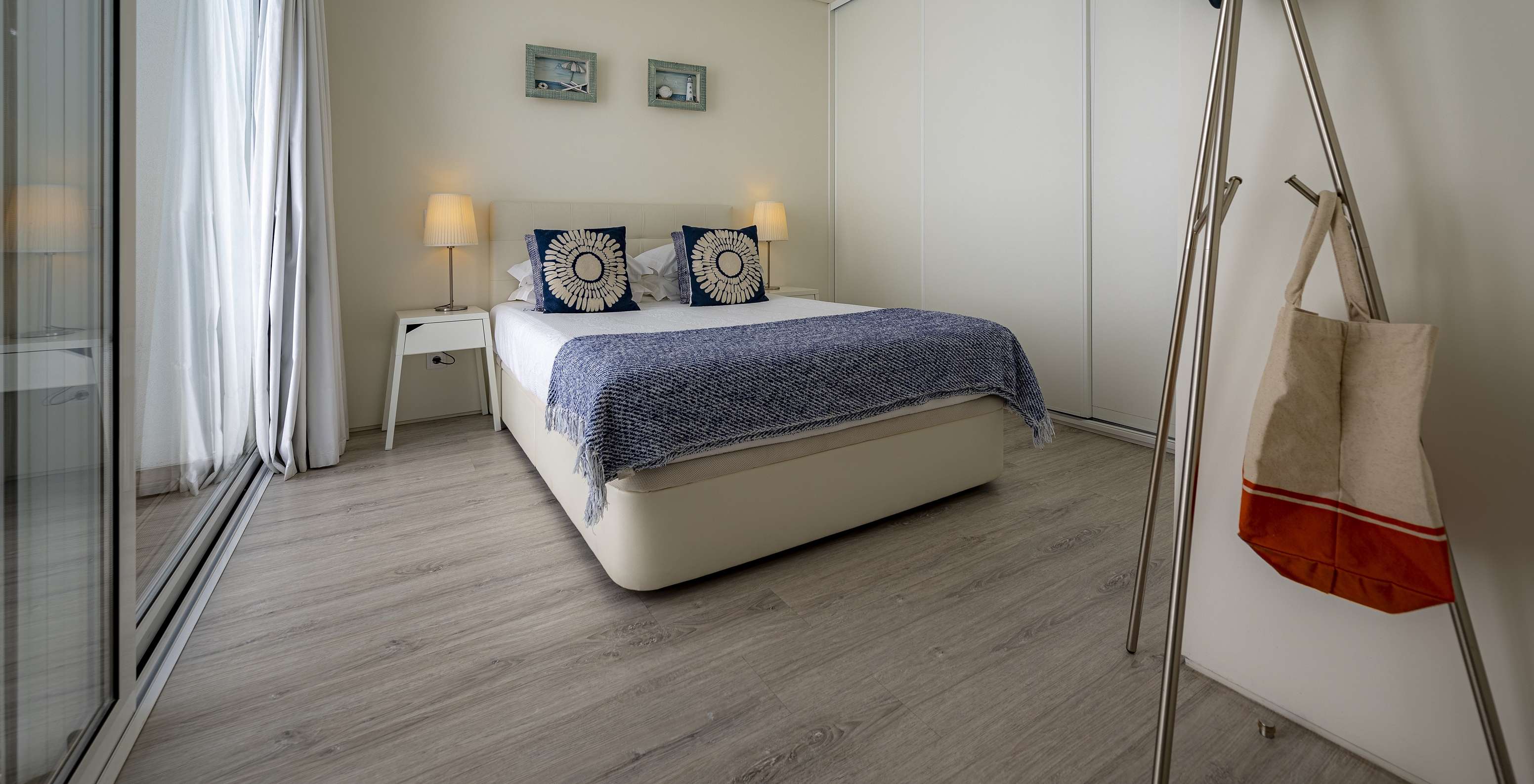 A Green Villa do Pestana Tróia Eco Resort tem uma cama de casal com duas mesas de cabeceira e uma colcha azul