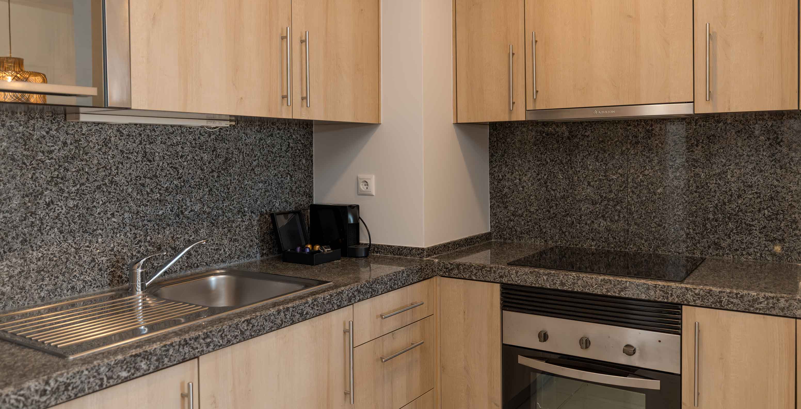 O Apartamento T1 Vista Jardim do Pestana Alvor Beach Villas tem uma cozinha com um fogão, um lava-loiça e máquina de café