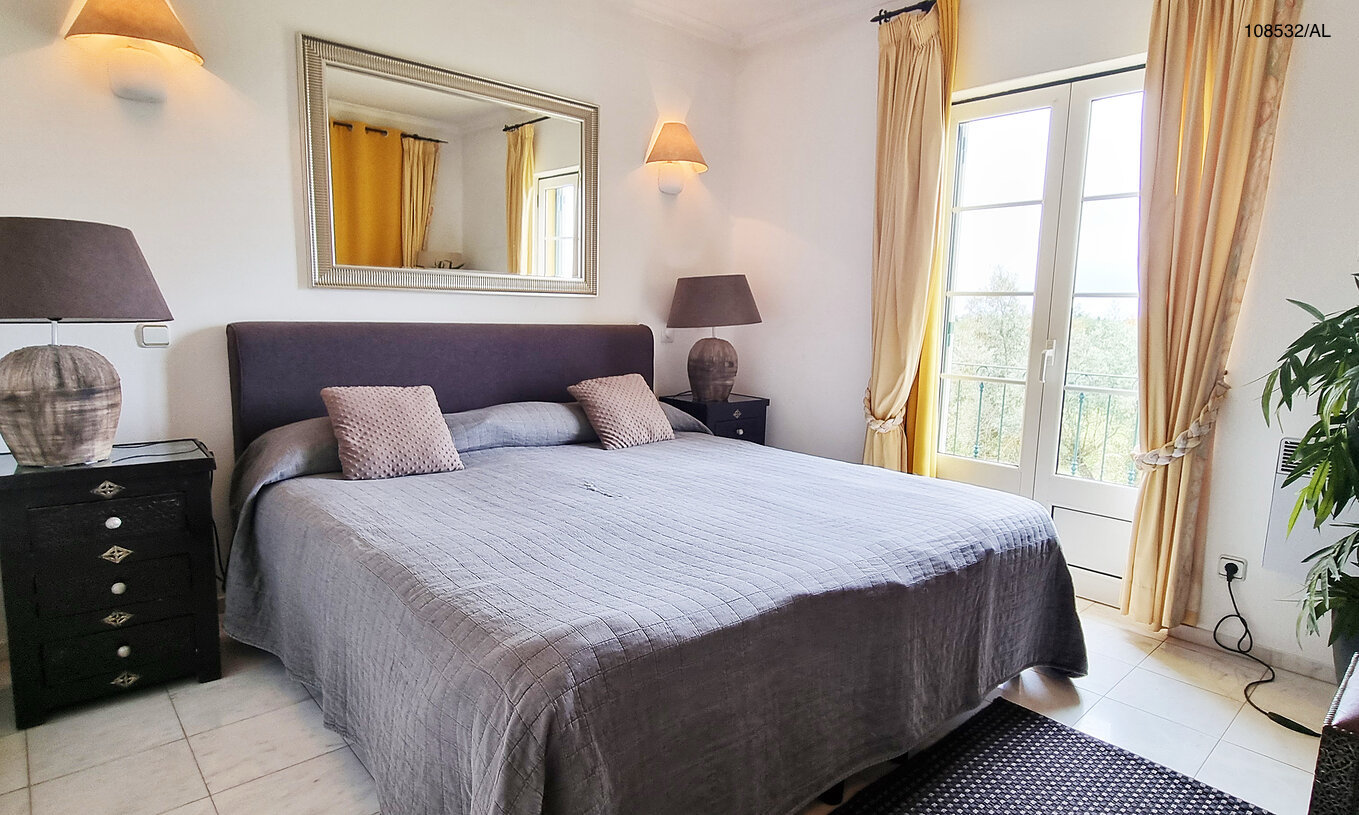 O Apartamento T1 Superior do Pestana Carvoeiro Golfe tem uma cama de casal com duas mesas de cabeceira e um espelho