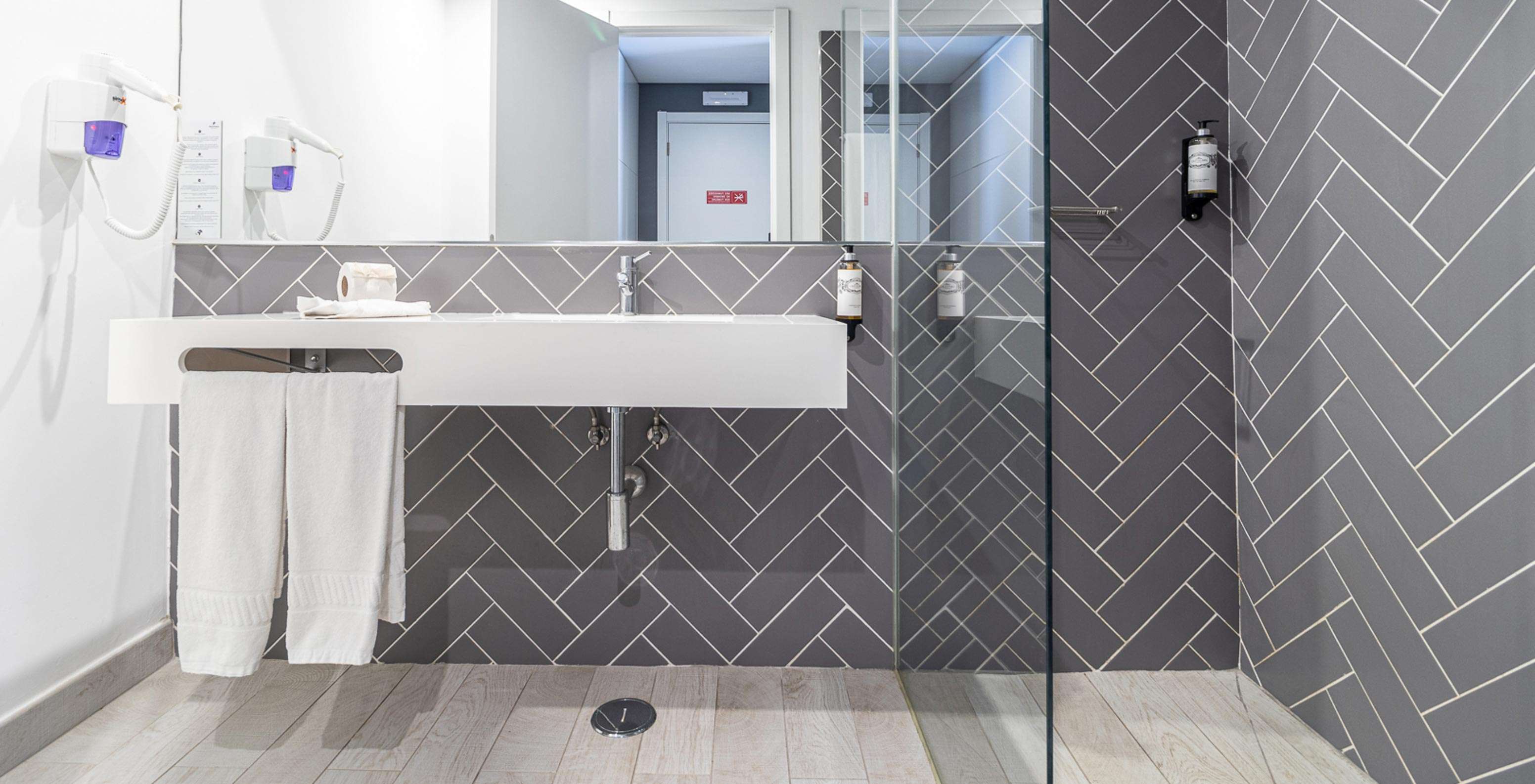 O Quarto Clássico do Pestana Gramacho Residences tem uma casa de banho moderna com lavatório branco, espelho e duche de vidro