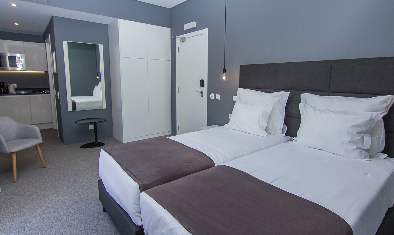 O Quarto Clássico do Pestana Gramacho Residences é um quarto moderno com duas camas, kitchenette e zona de estar