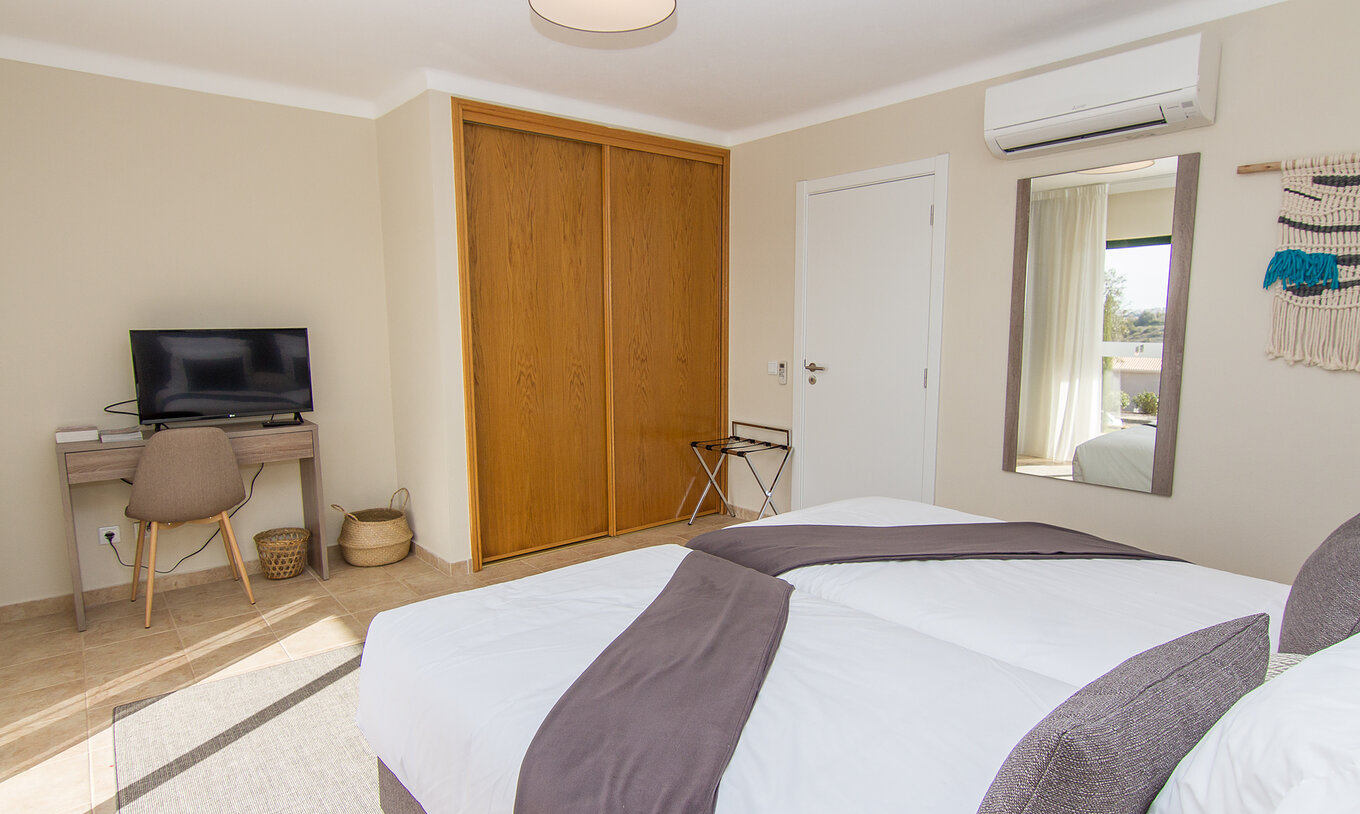 O Apartamento T1 do Pestana Gramacho Residences tem um espelho na parede, ar condicionado, armário e uma televisão