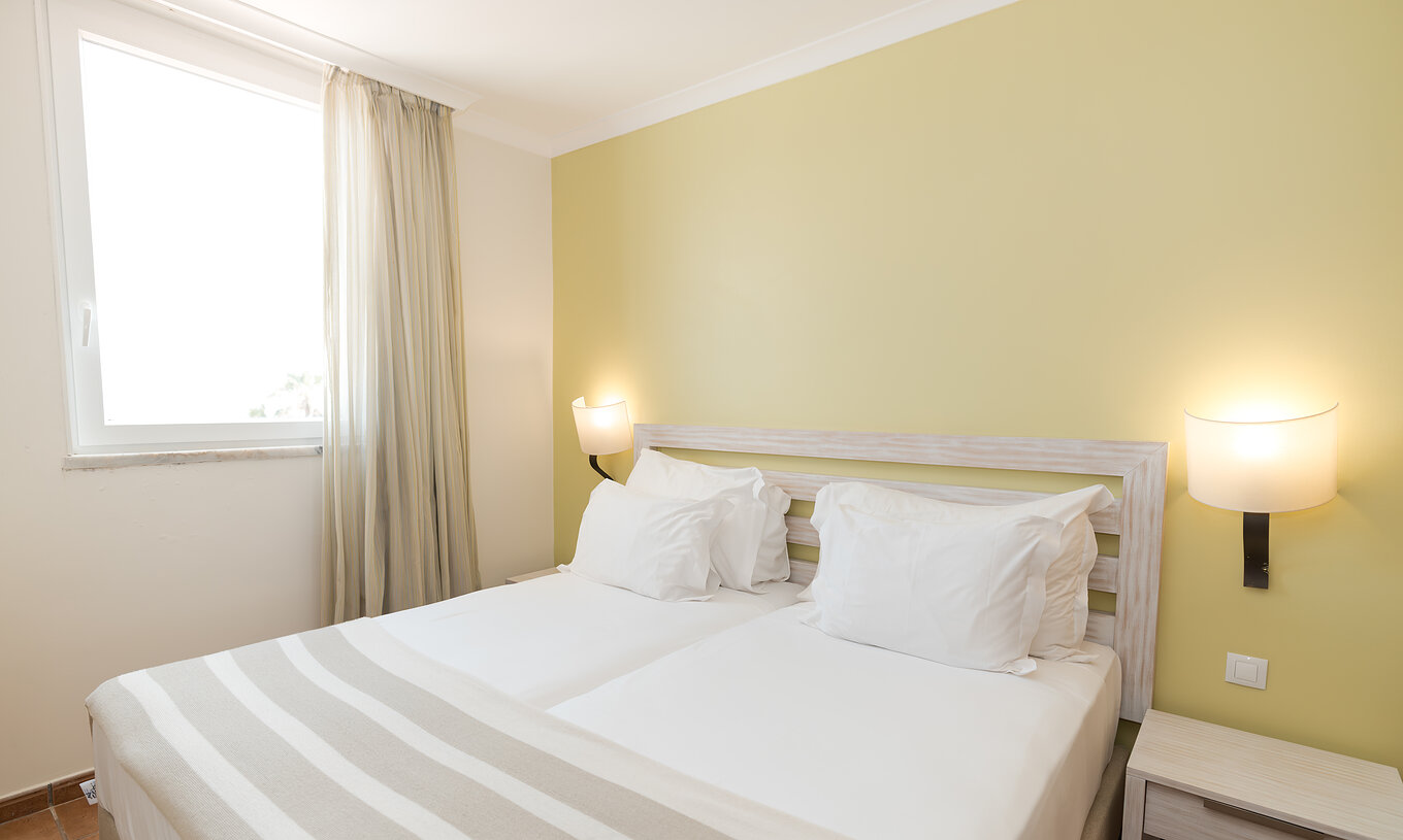 A Suite T2 do Pestana Viking conta com duas camas individuais com candeeiro e mesa de cabeceira