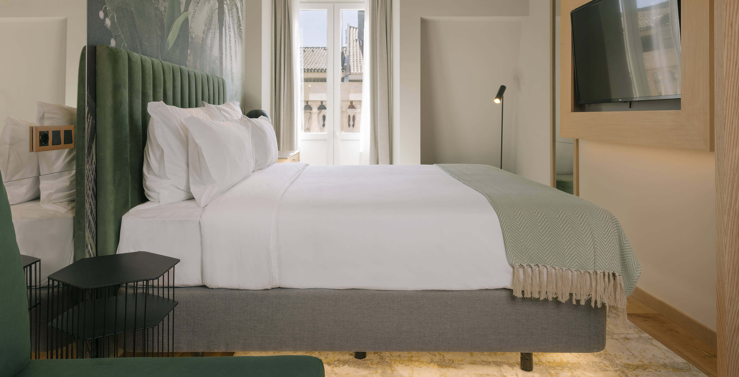 O Quarto Superior Plus do Pestana Rua Augusta Lisboa tem uma cama de casal, papel de parede de palmeiras e uma janela