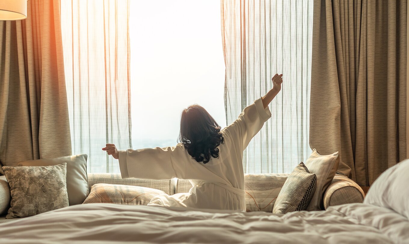 O Apartamento T1 do Pestana Madeira Beach Club tem uma janela grande com cortinas beje, um sofá e uma cama de casal