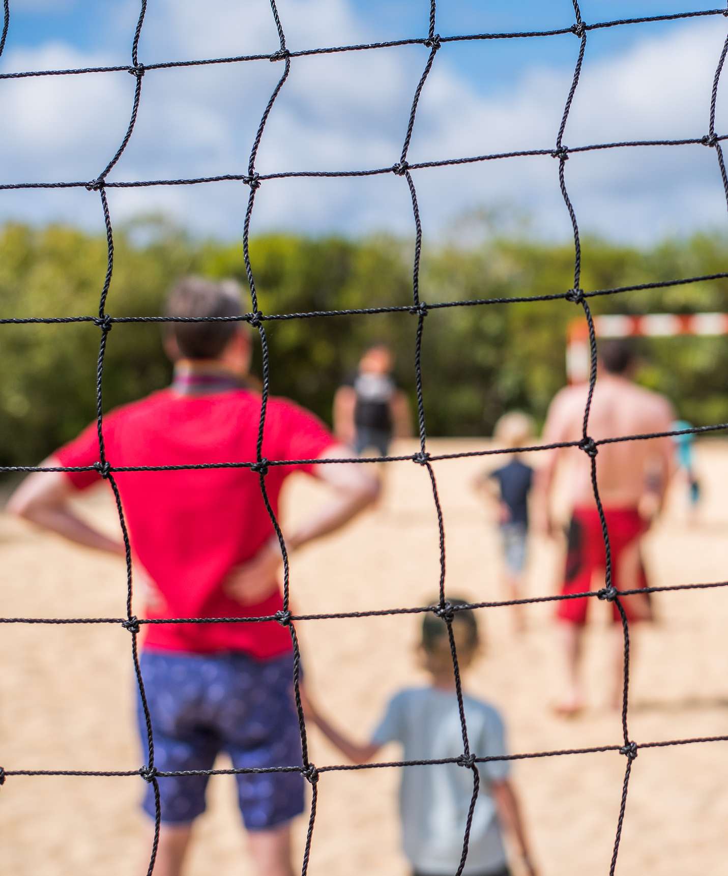 Campo de Jogos no Hotel com Tudo Incluído e Spa no Porto Santo, com pais e filhos a jogarem futebol na praia