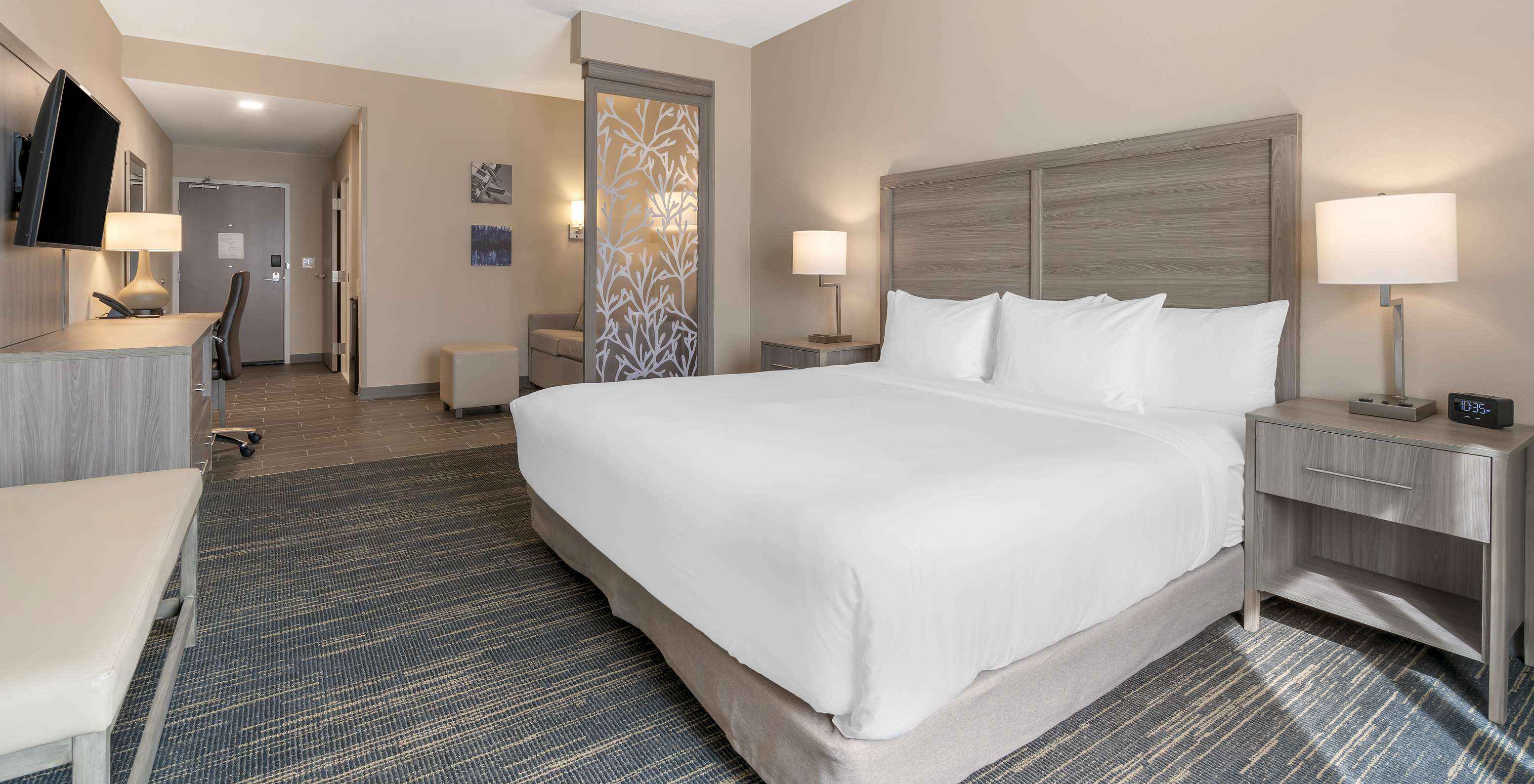 A Suite King do Pestana Orlando Suites Lake Buena Vista conta com cama de casal, mesa de cabeceira e televisão