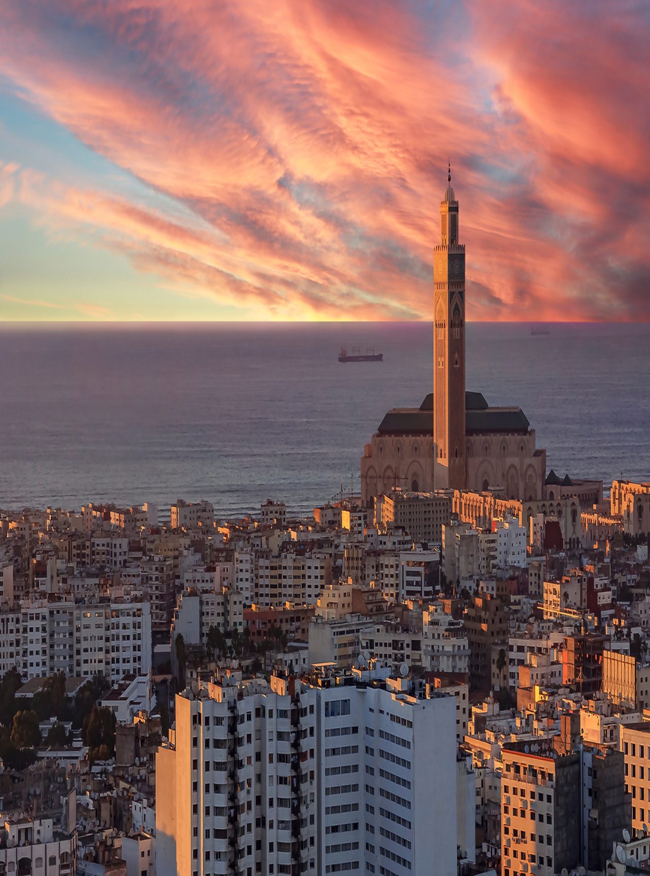 Luftaufnahme über Casablanca, Sonnenuntergang beleuchtet Gebäude, Himmel am Horizont, Meer und Turm