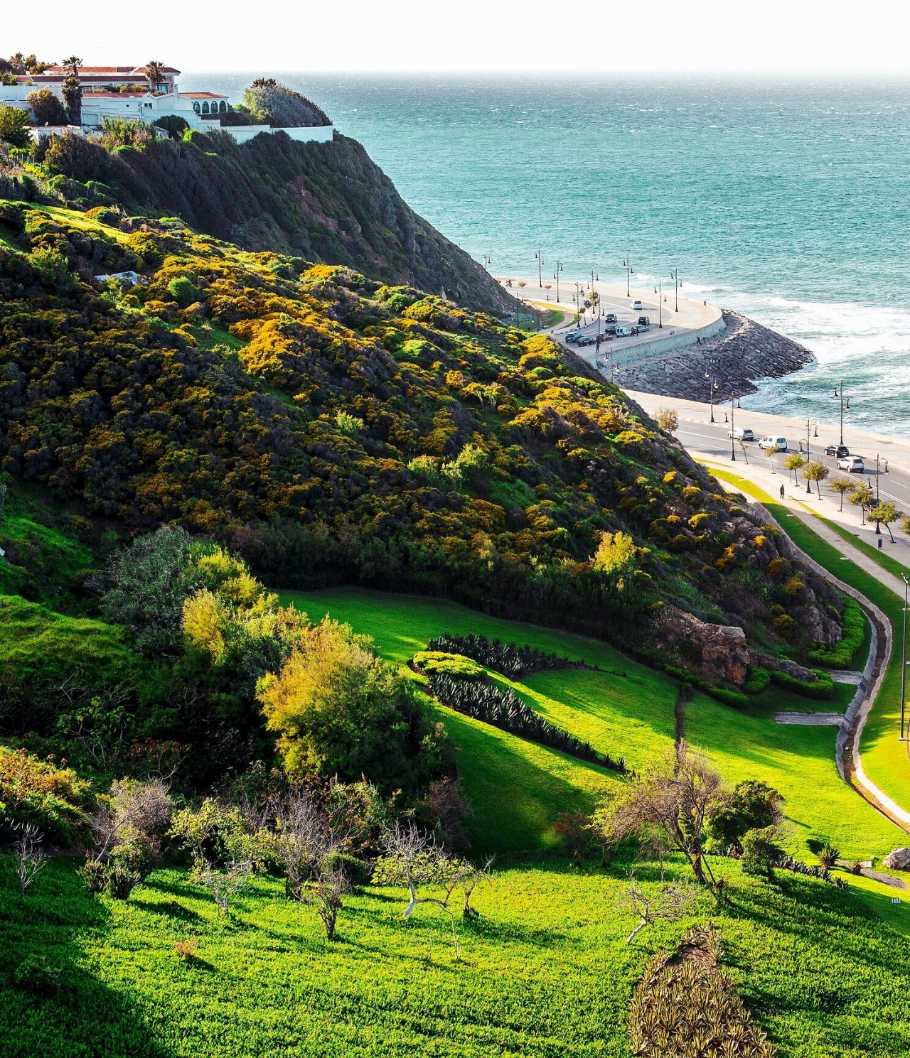 Küstenstraße in Tanger, auf der Autos nahe dem Meer fahren, mit Blick auf die Wellen und den Horizont